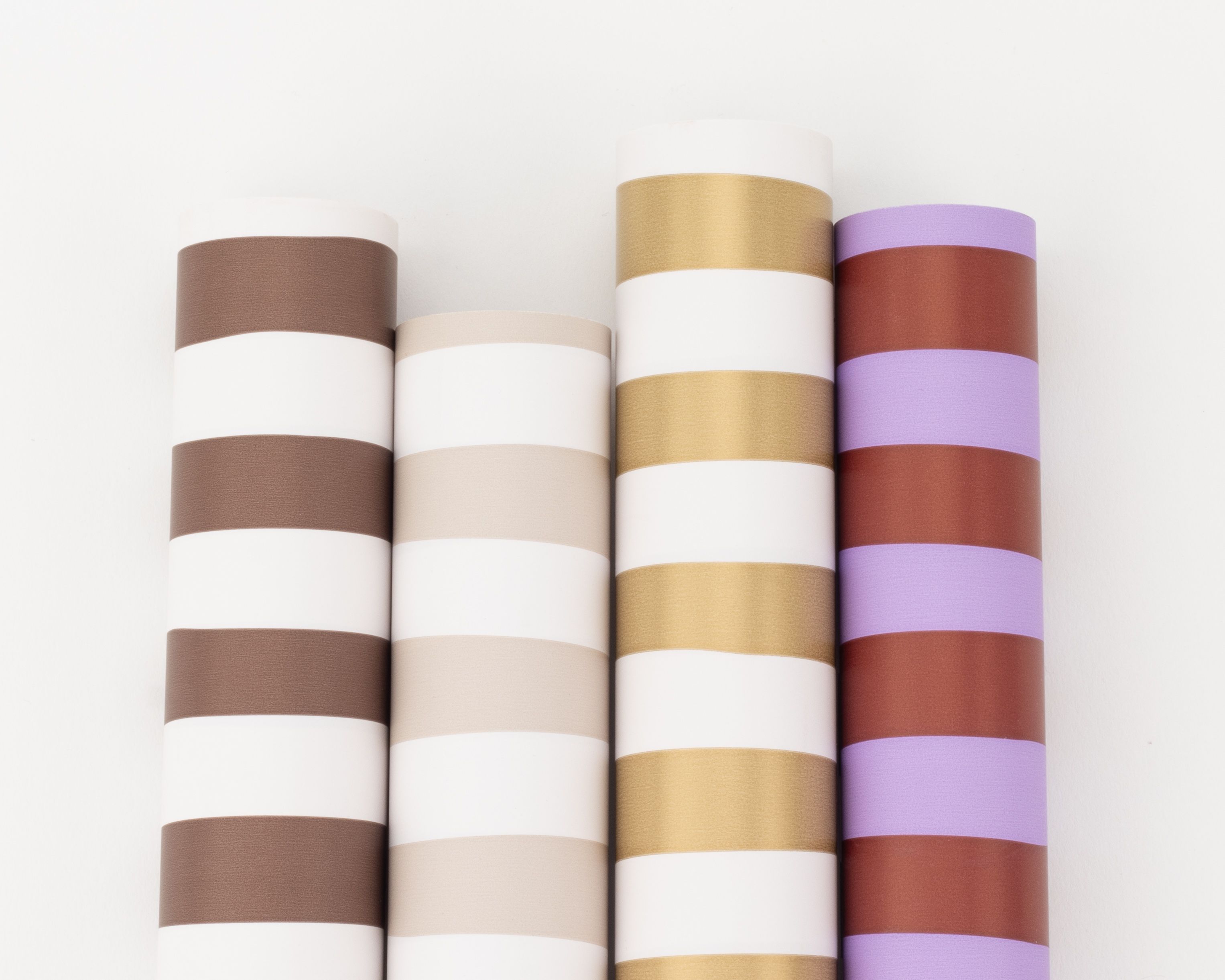 Geschenkpapier-Set mit vier nebeneinander liegenden Rollen in Braun, Beige, Gold, Lilac und Weinrot, alle mit Streifenmustern