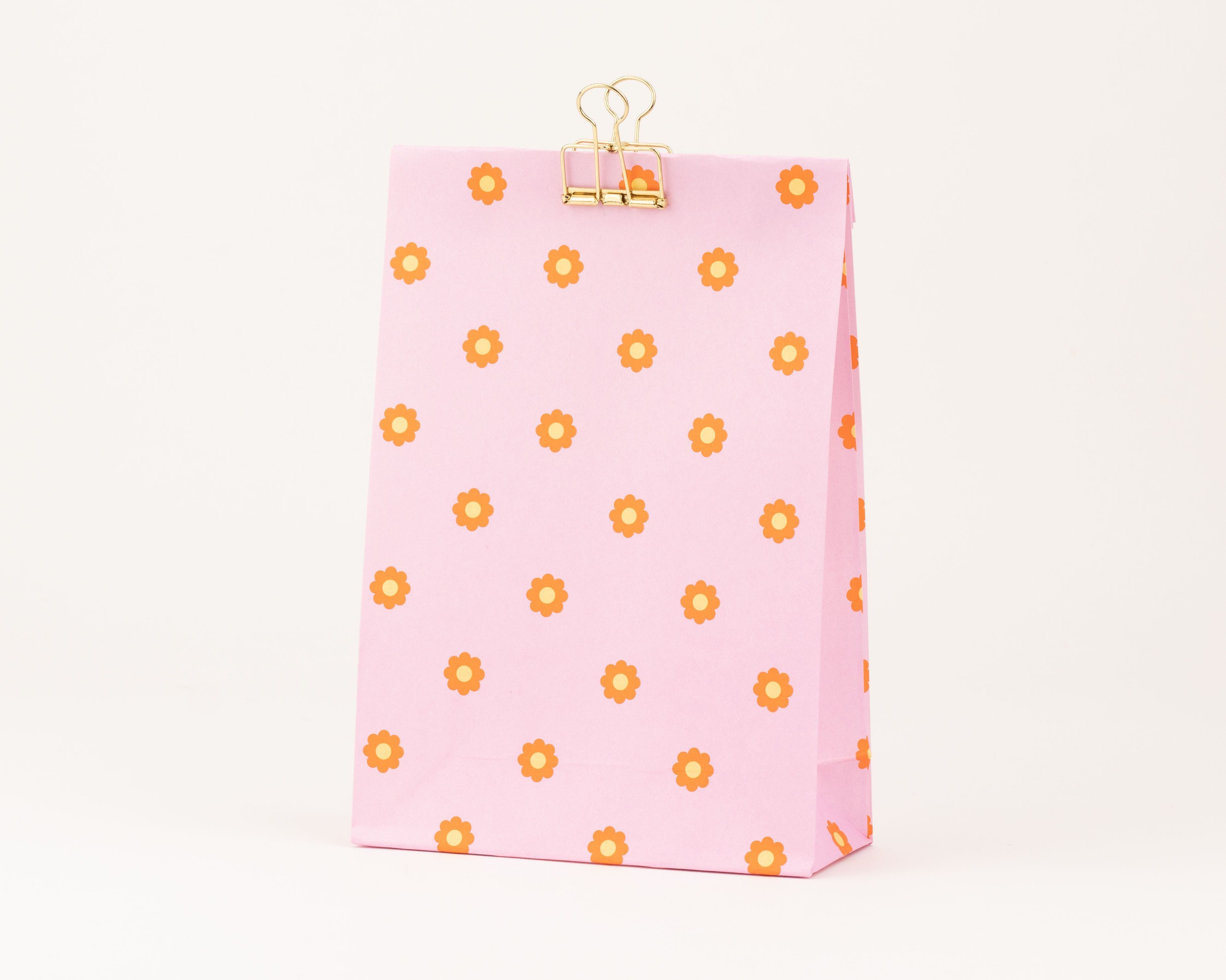 Papiertüten Blockbodenbeutel in Pink mit einem Muster aus orangefarbenen und gelben Gänseblümchen