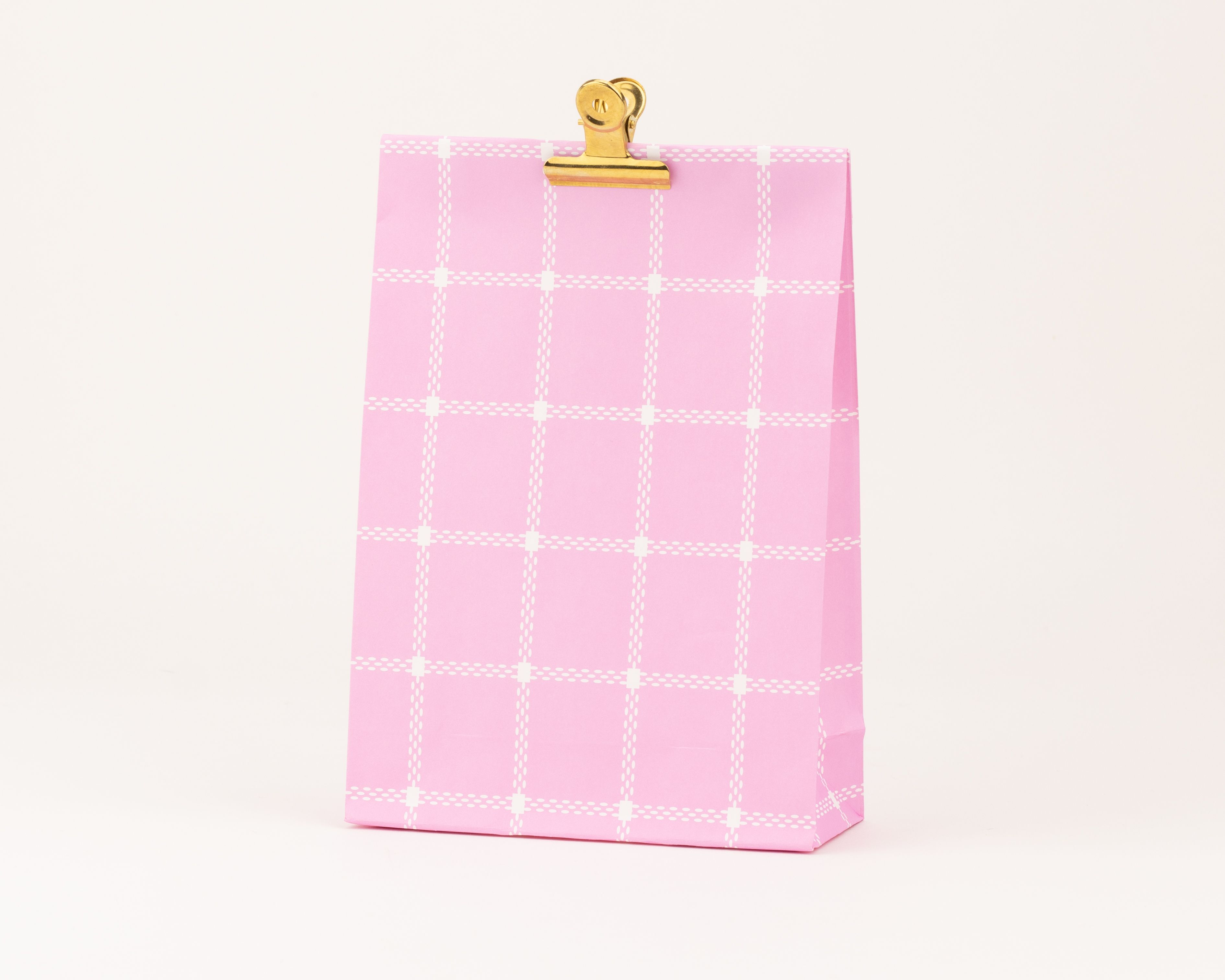 Papiertüten Blockbodenbeutel mit einem rosa Grundton und einem weißen Karomuster aus Punkten und Strichen