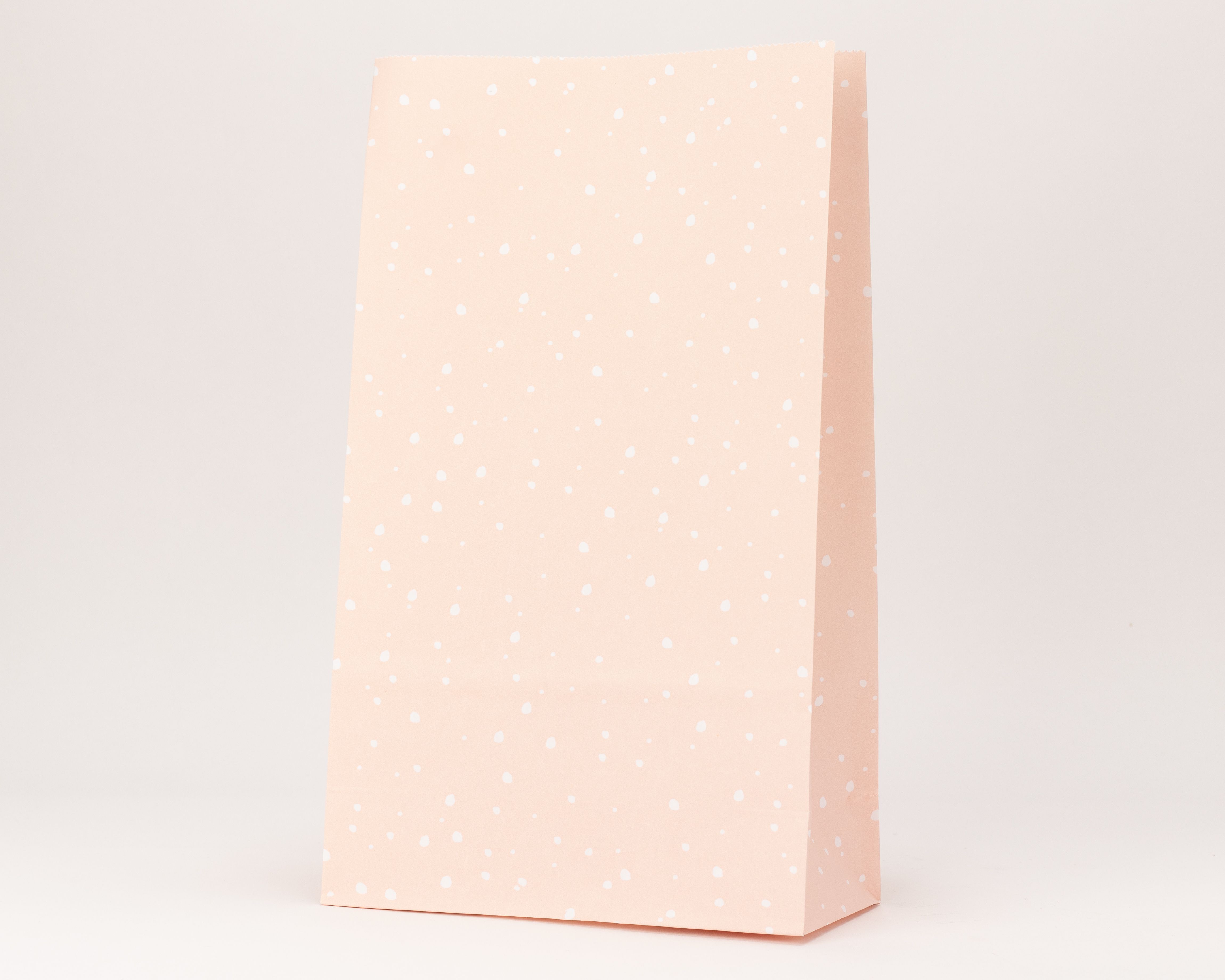 Blockbodenbeutel aus rosa Papier mit einem flächendeckenden Muster aus weißen Konfetti Punkten