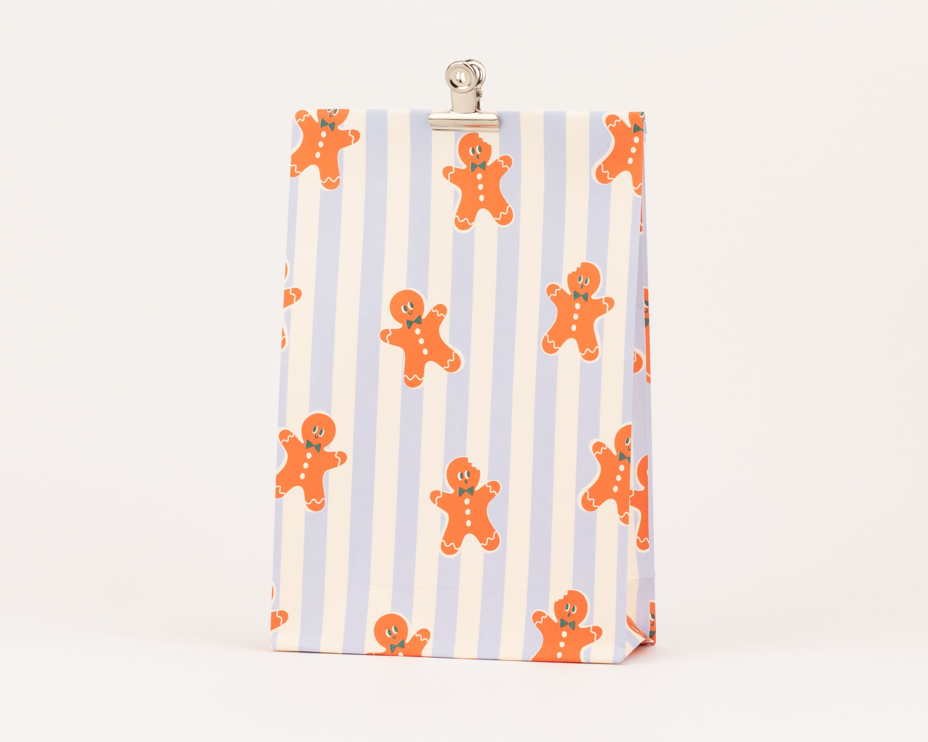 Blockbodenbeutel mit einem Muster aus orangefarbenen Lebkuchenmännchen auf elfenbein- und blau gestreiften Hintergrund
