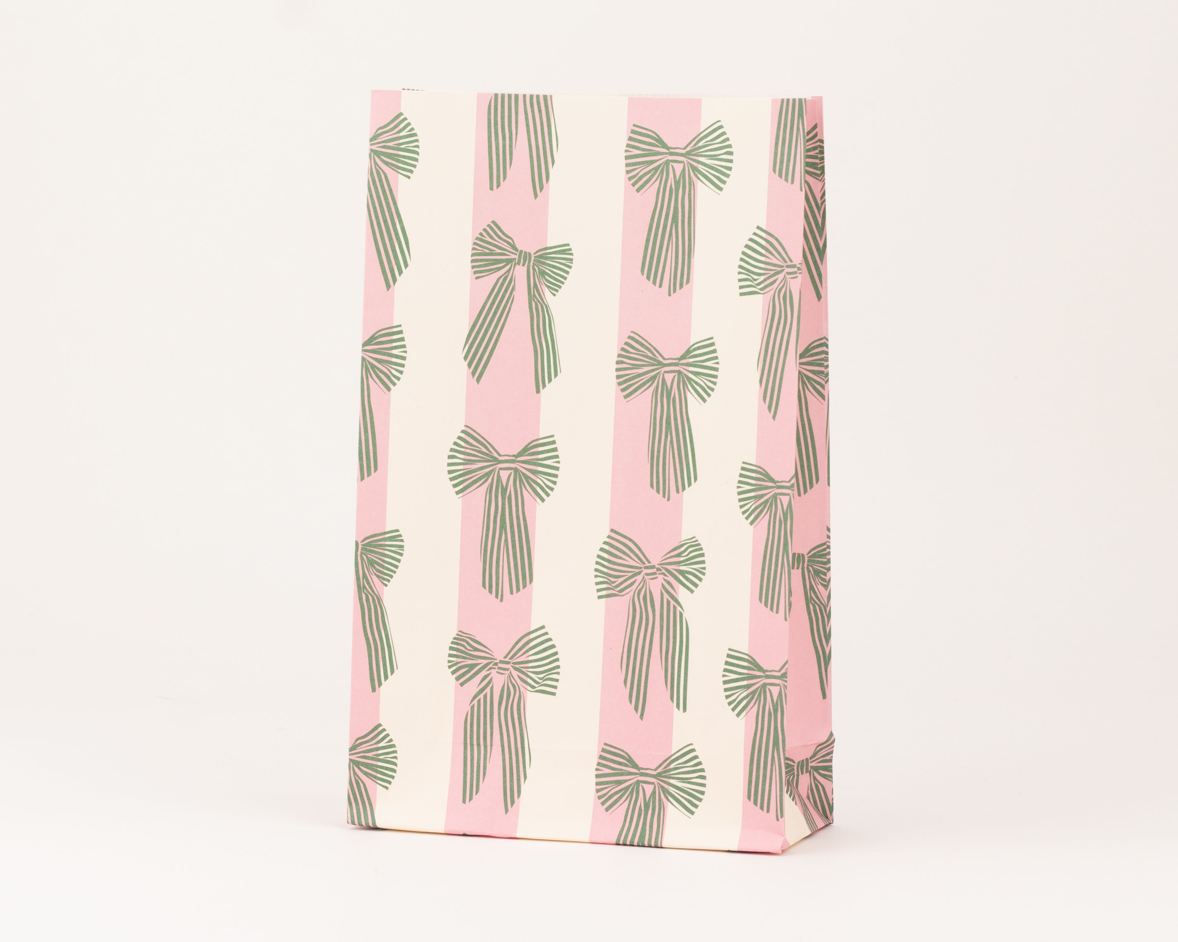 Papiertüten Blockbodenbeutel mit vertikalen Streifen in Litschi und Vanille. Die Tüten sind zusätzlich mit grünen Schleifen in Waldgrün bedruckt