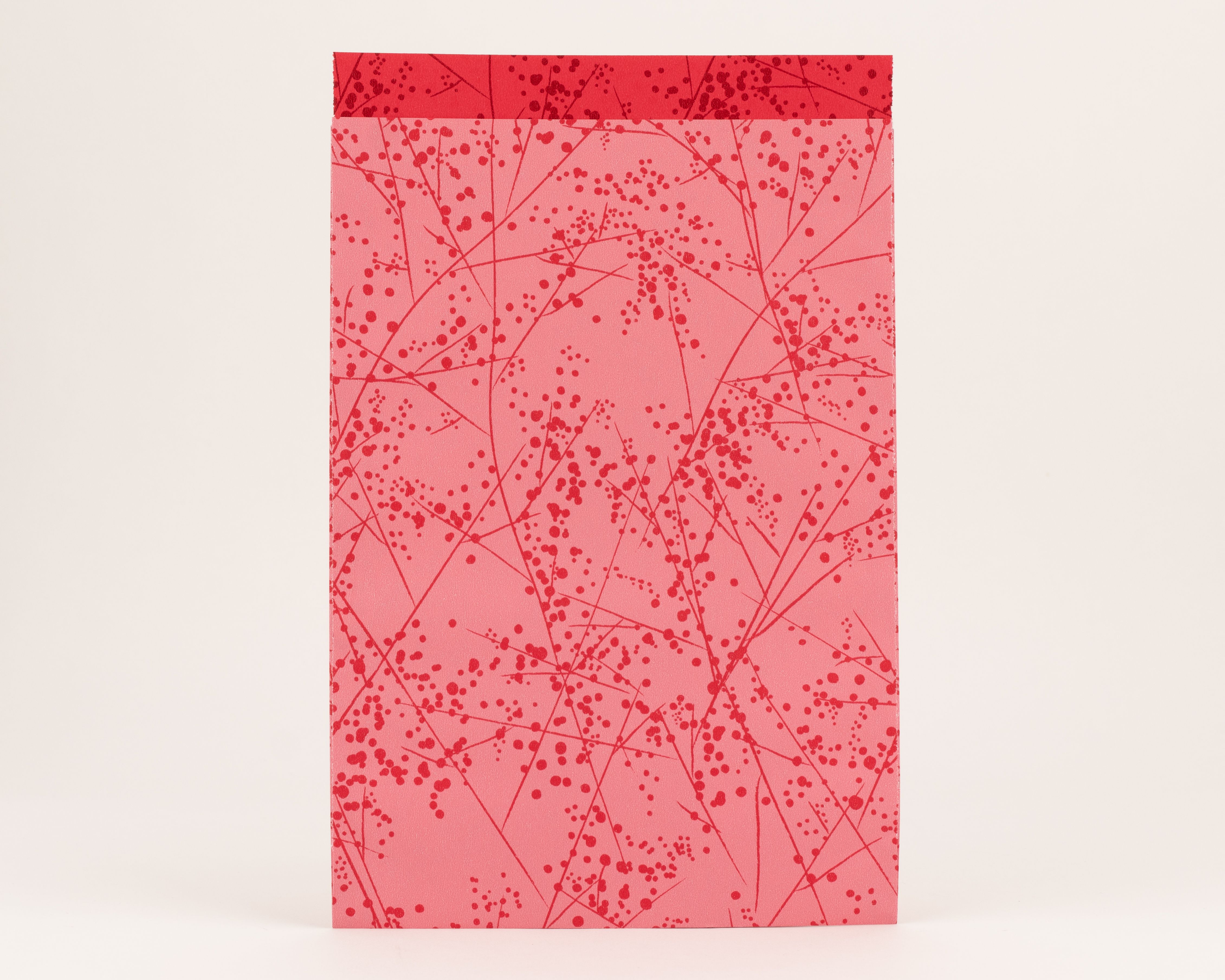 Flachbeutel in Pink mit filigranem Muster aus roten Ästen und Beeren, dazu eine einfarbig rote Innenseite