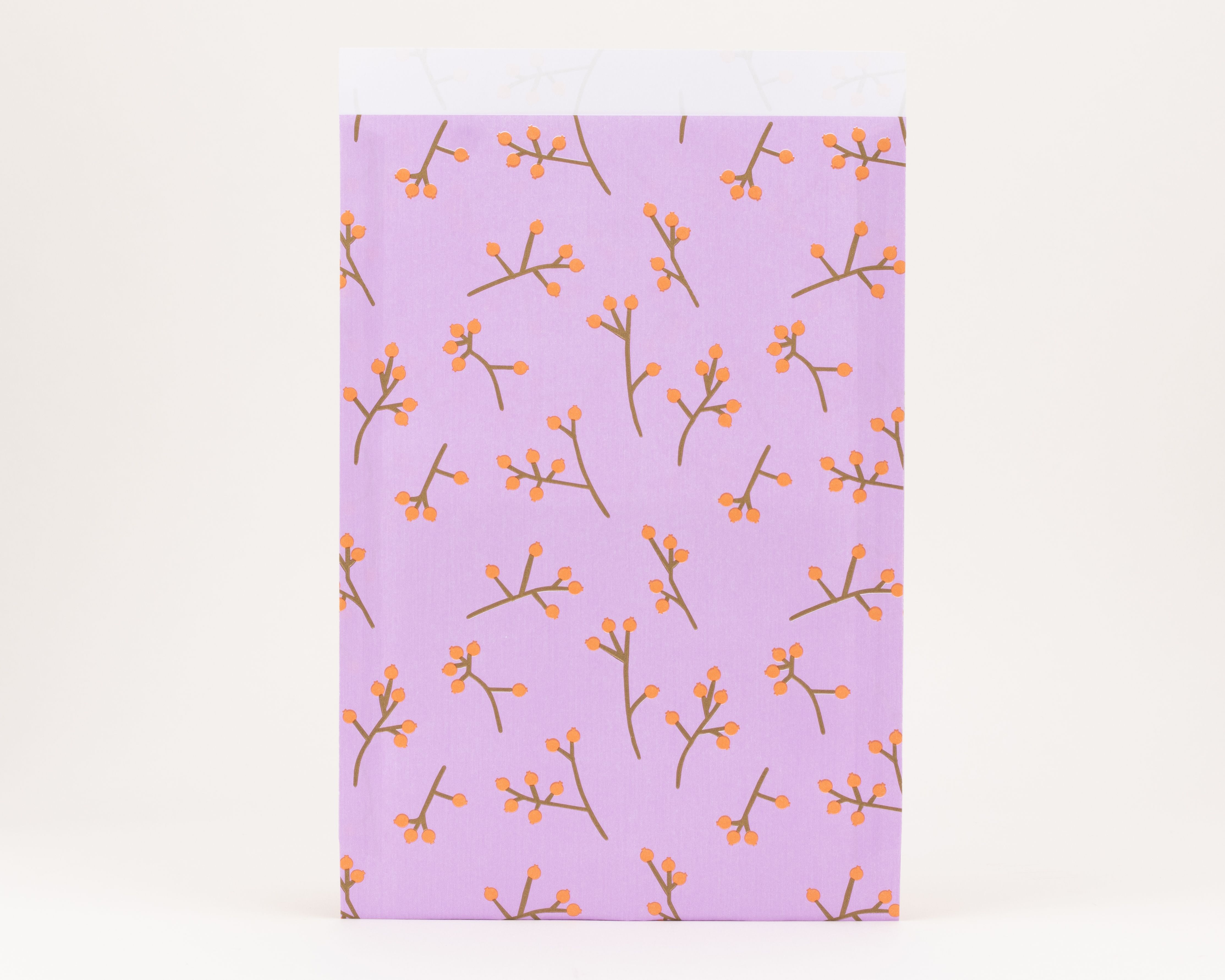 Flachbeutel zeigen ein Flieder mit einem Muster aus braunen Zweigen und Kaki-orangen Beeren, die Innenseite ist reinweiß