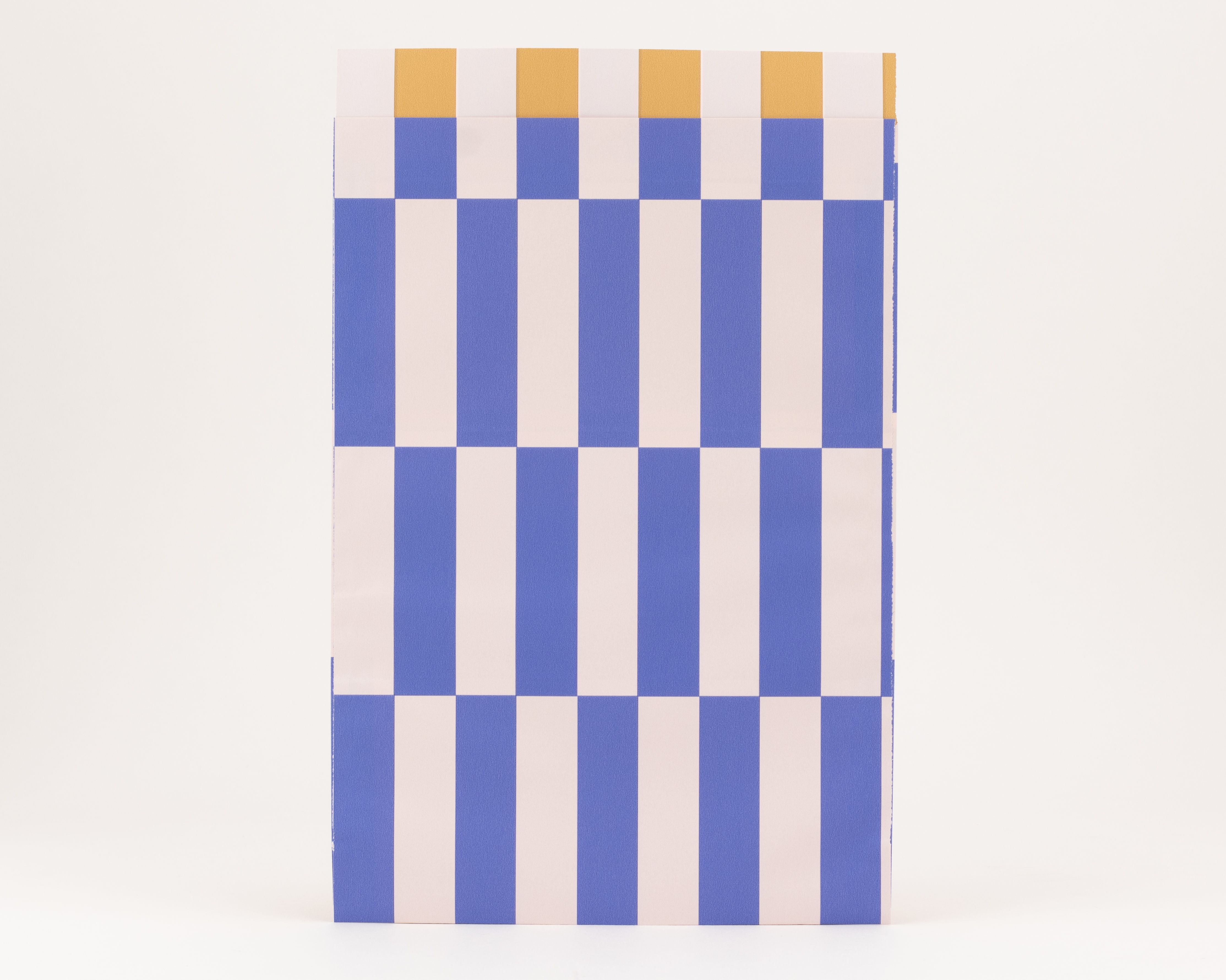 Flachbeutel mit einem markanten Schachbrettmuster aus blauen und elfenbeinfarbenen Streifen auf der Außenseite und einer ockerfarbenen Innenseite