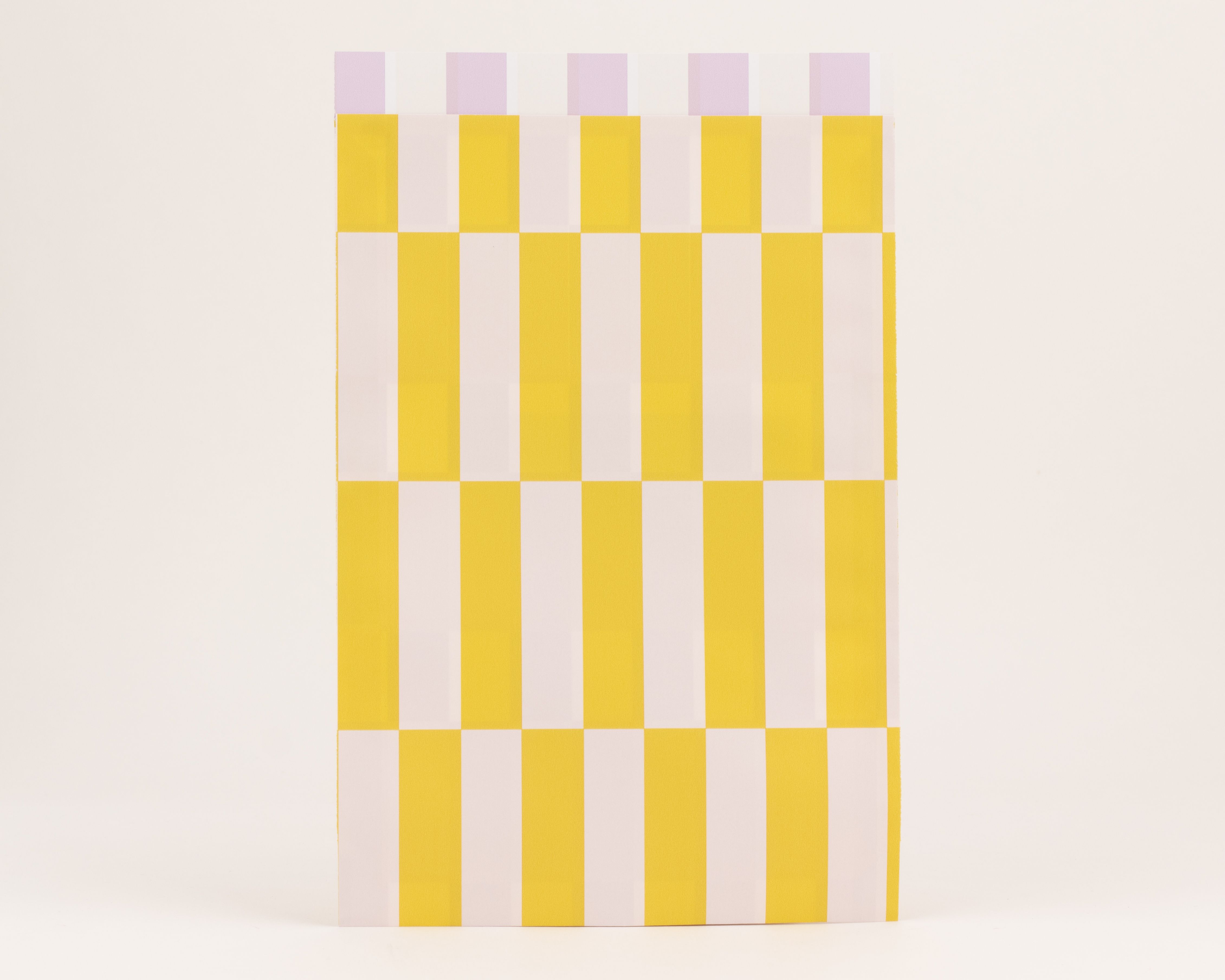 Flachbeutel mit einem Muster aus vertikalen Streifen in Gelb und Weiß auf der Außenseite. Die Innenseite zeigt Streifen in Flieder und Weiß