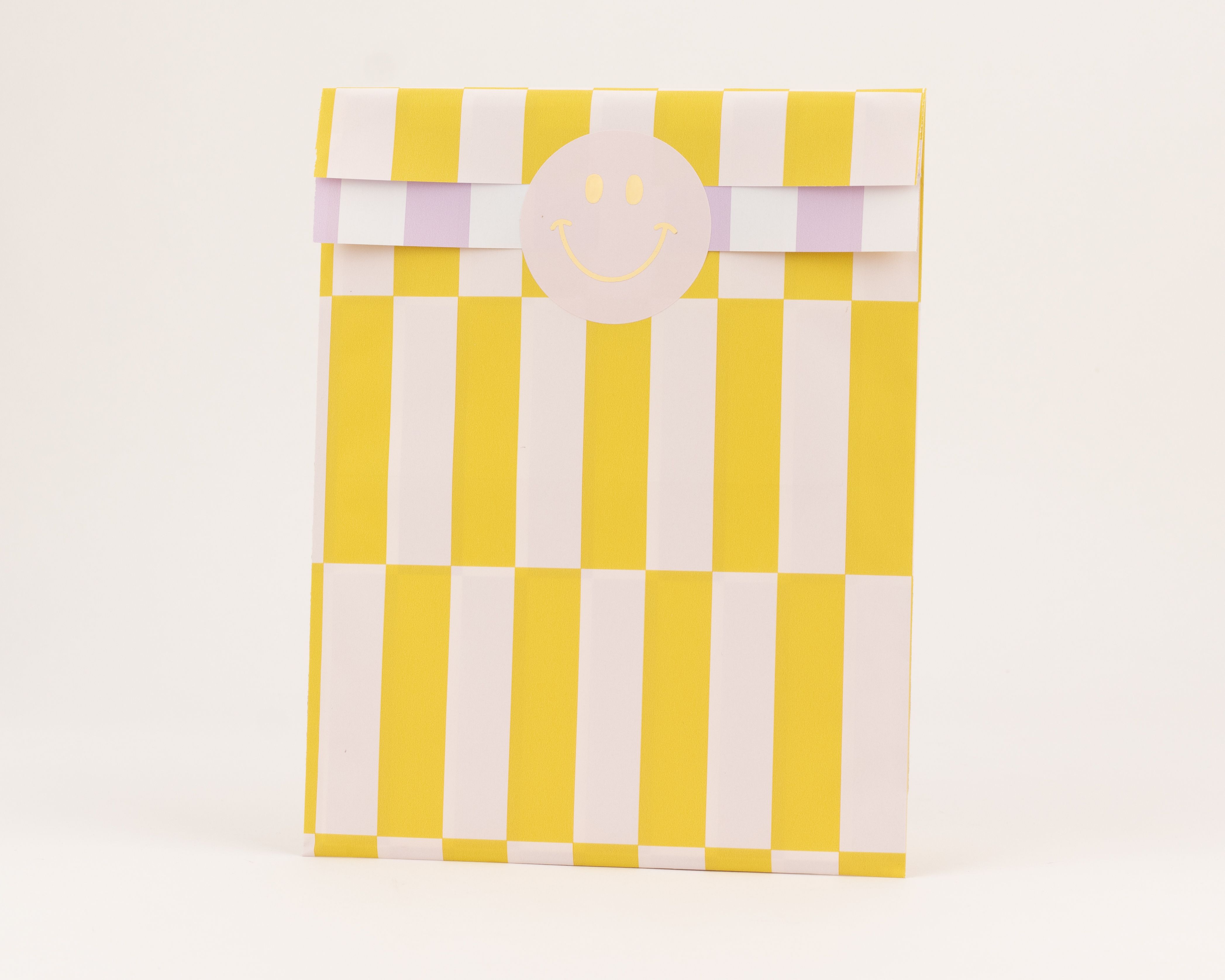 Flachbeutel mit vertikalen gelb-weißen Streifen auf der Außenseite und horizontalen flieder-weißen Streifen auf der Innenseite