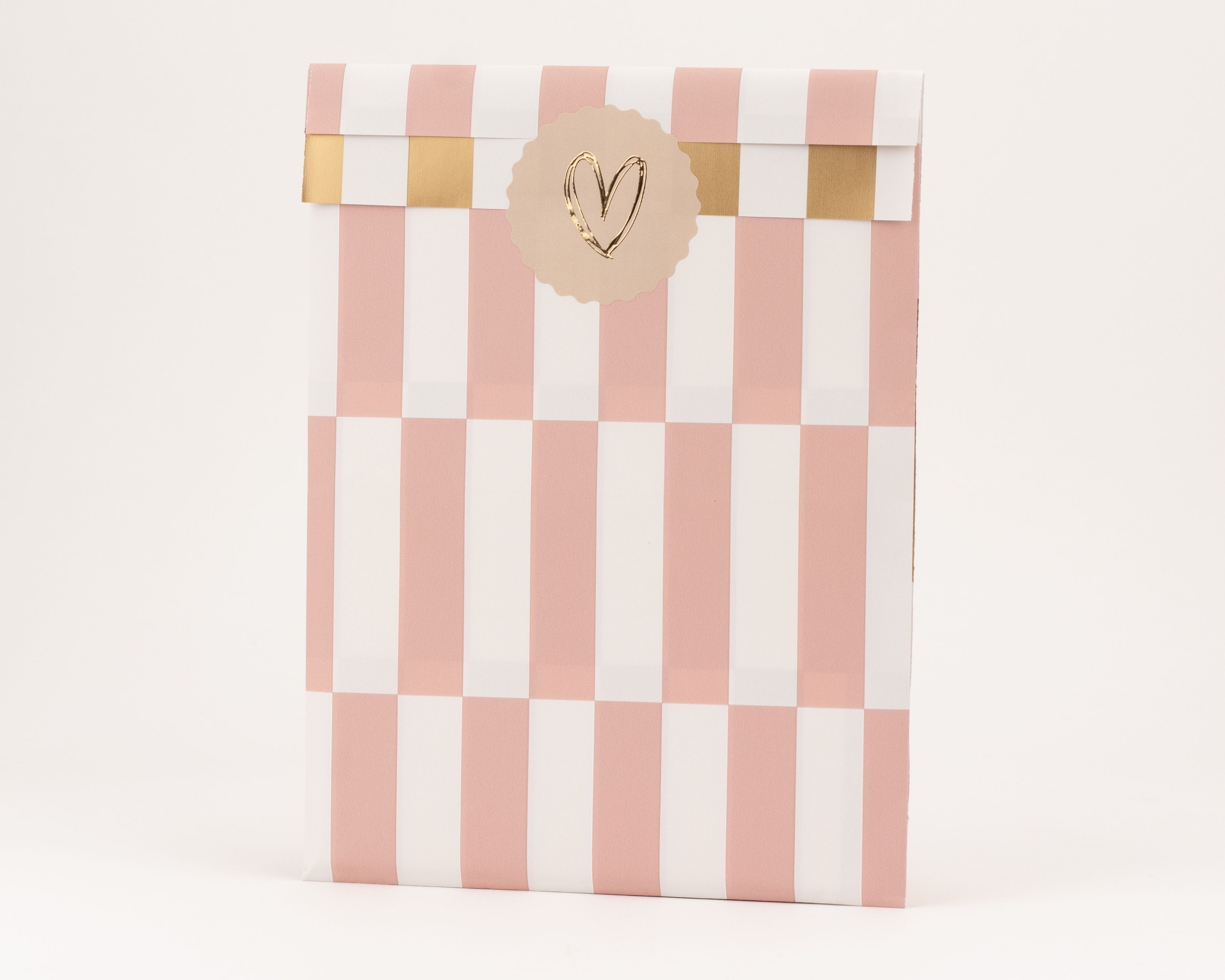 Papiertüten mit rosa-weißen Streifen und einer gold-weißen Innenseite im Blockmuster mit Goldeffekt und einem goldenen Herz-Aufkleber.