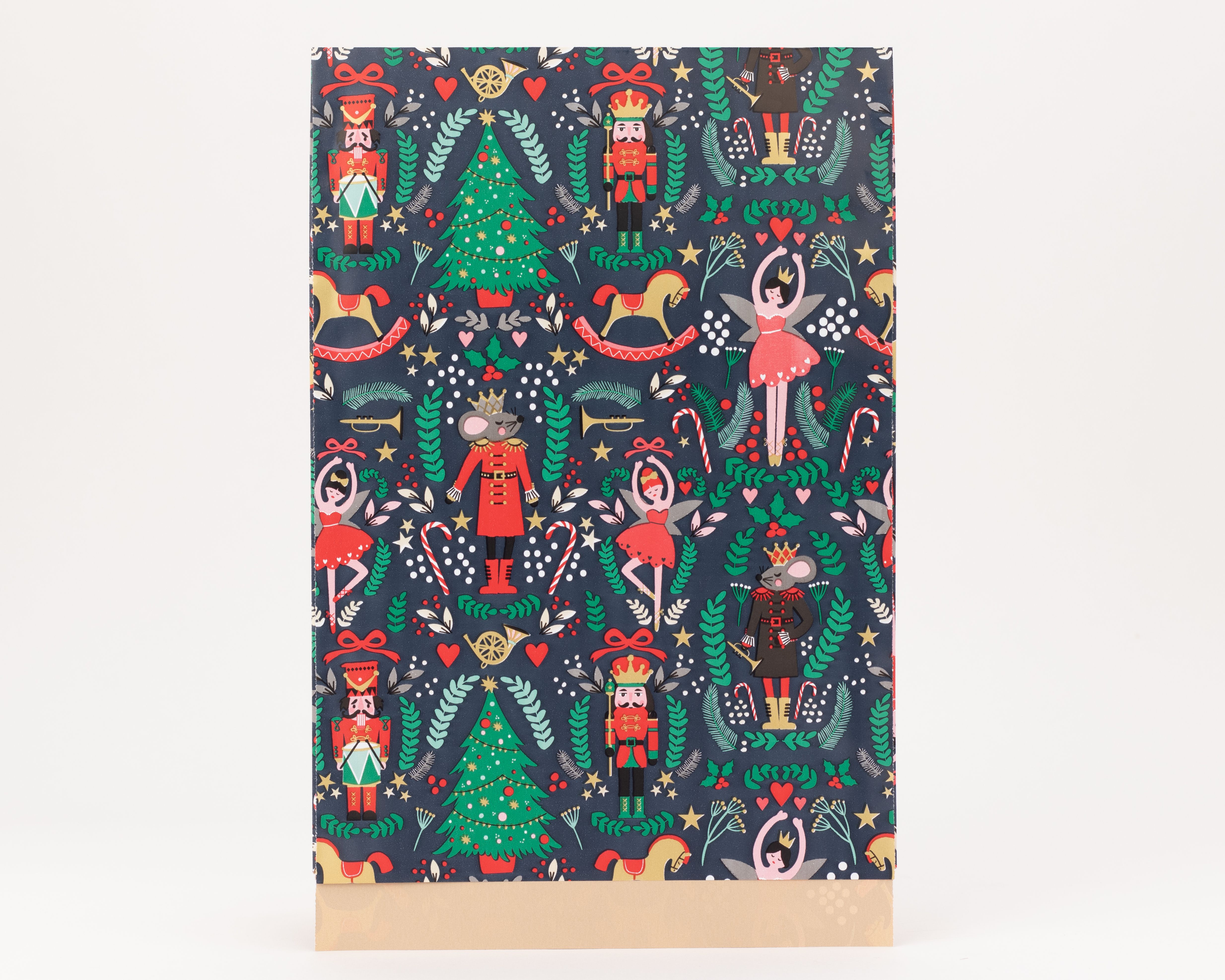 Flachbeutel mit einem dunkelblauen Weihnachtsmuster, das Nussknacker, Ballerinas, Mauskönige und Weihnachtsbäume zeigt. Die Innenseite ist braun