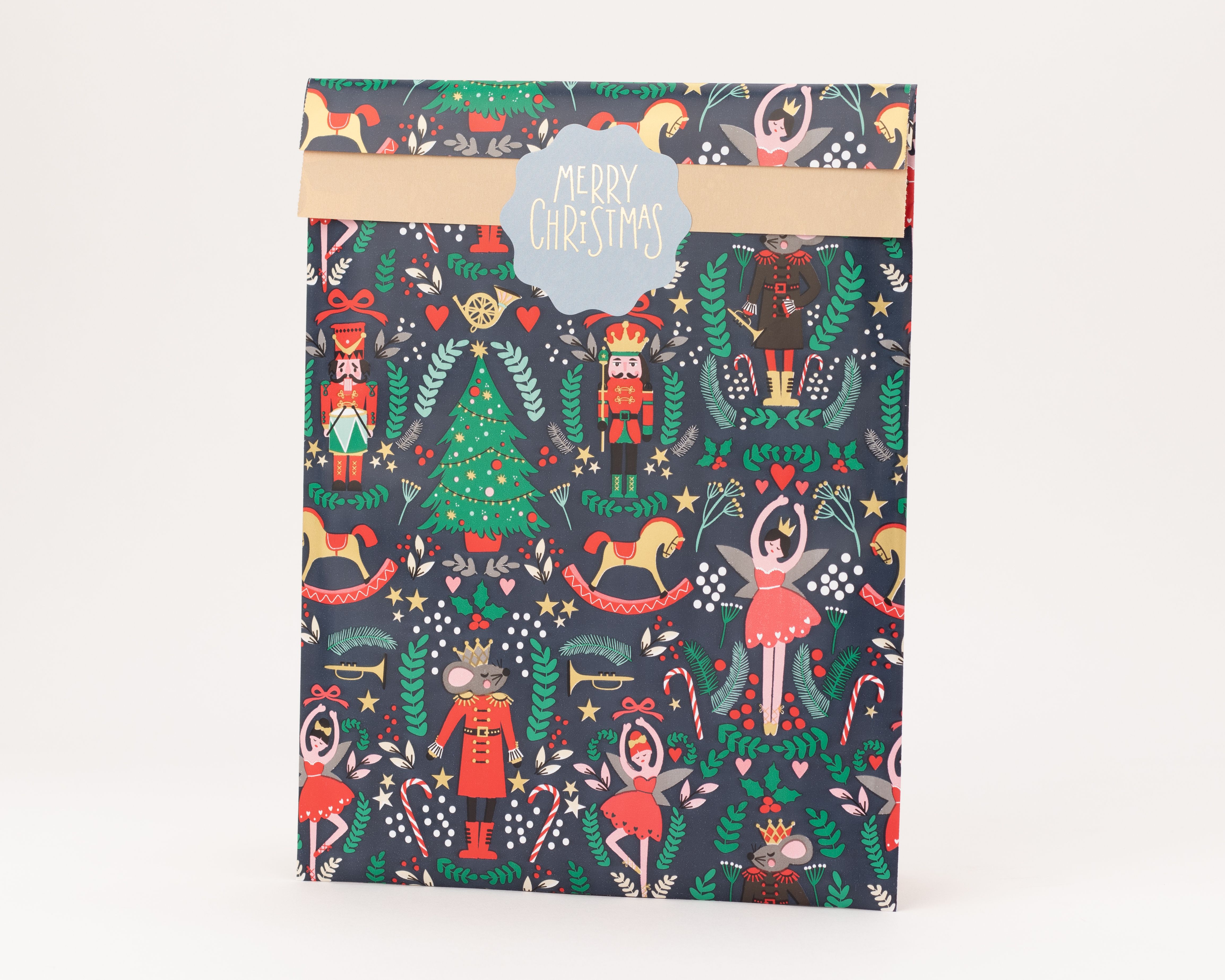 Flachbeutel mit blauem Hintergrund und einem bunten Weihnachtsmotiv mit Nussknackerfiguren und Bäumen, die Innenseite ist hellbraun