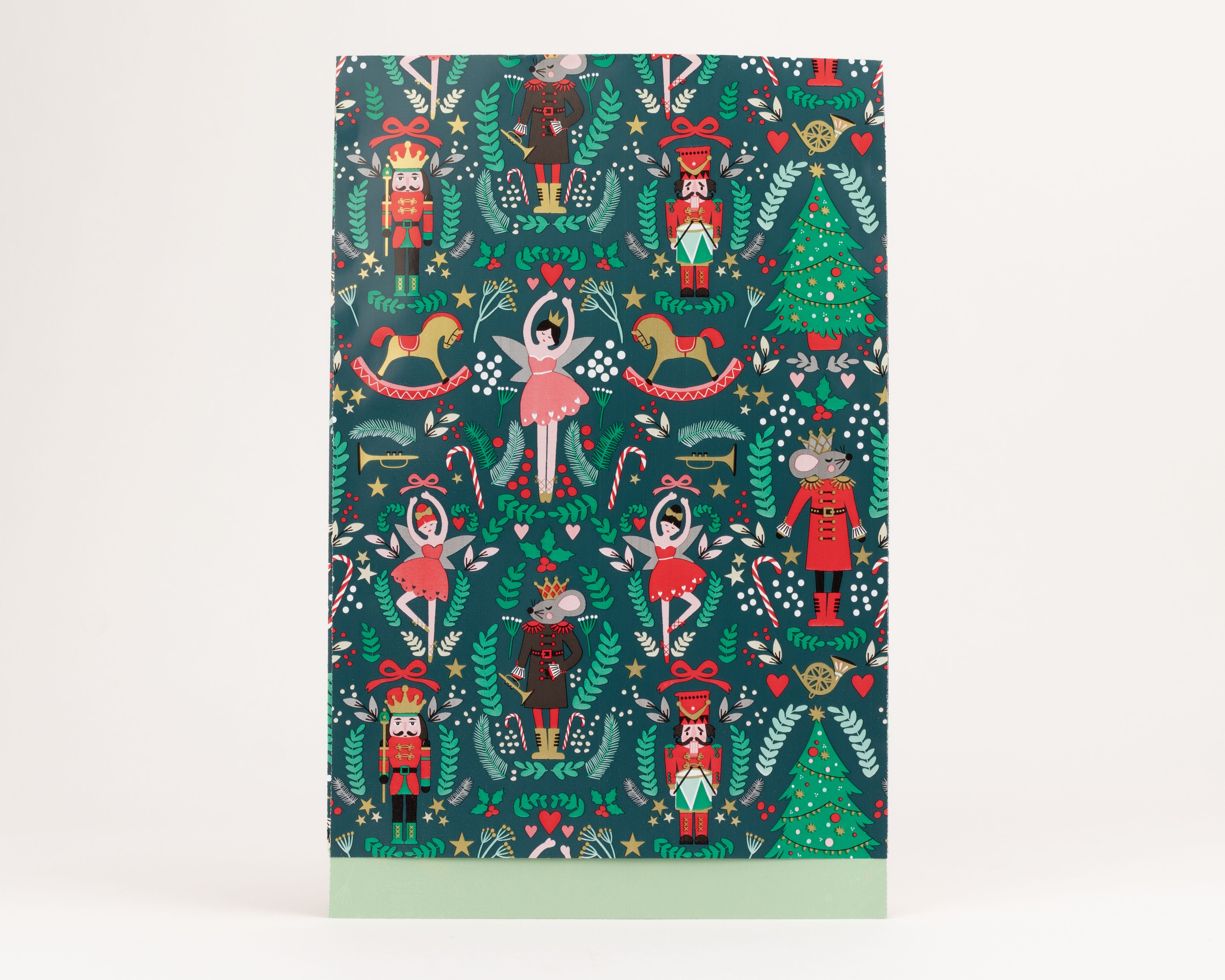 Flachbeutel mit dunkelgrünem Weihnachtsmotiv von Nussknackern, Mäusekönigen und Ballerinas. Die Innenseite ist hellgrün