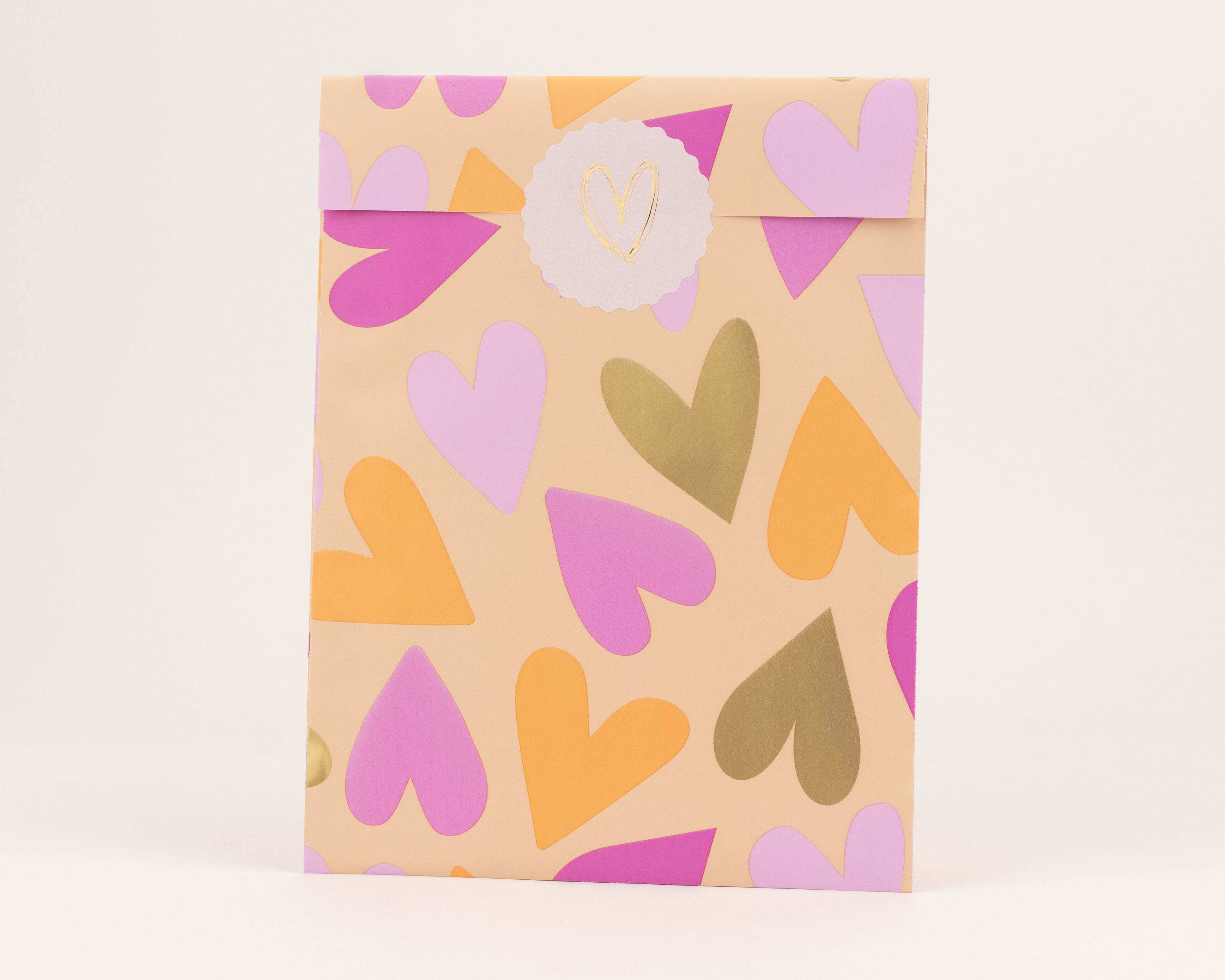 Papiertüten mit Herzenmuster in Pink, Orange und Gold auf pfirsichfarbenem Grund, Innenseite Pink