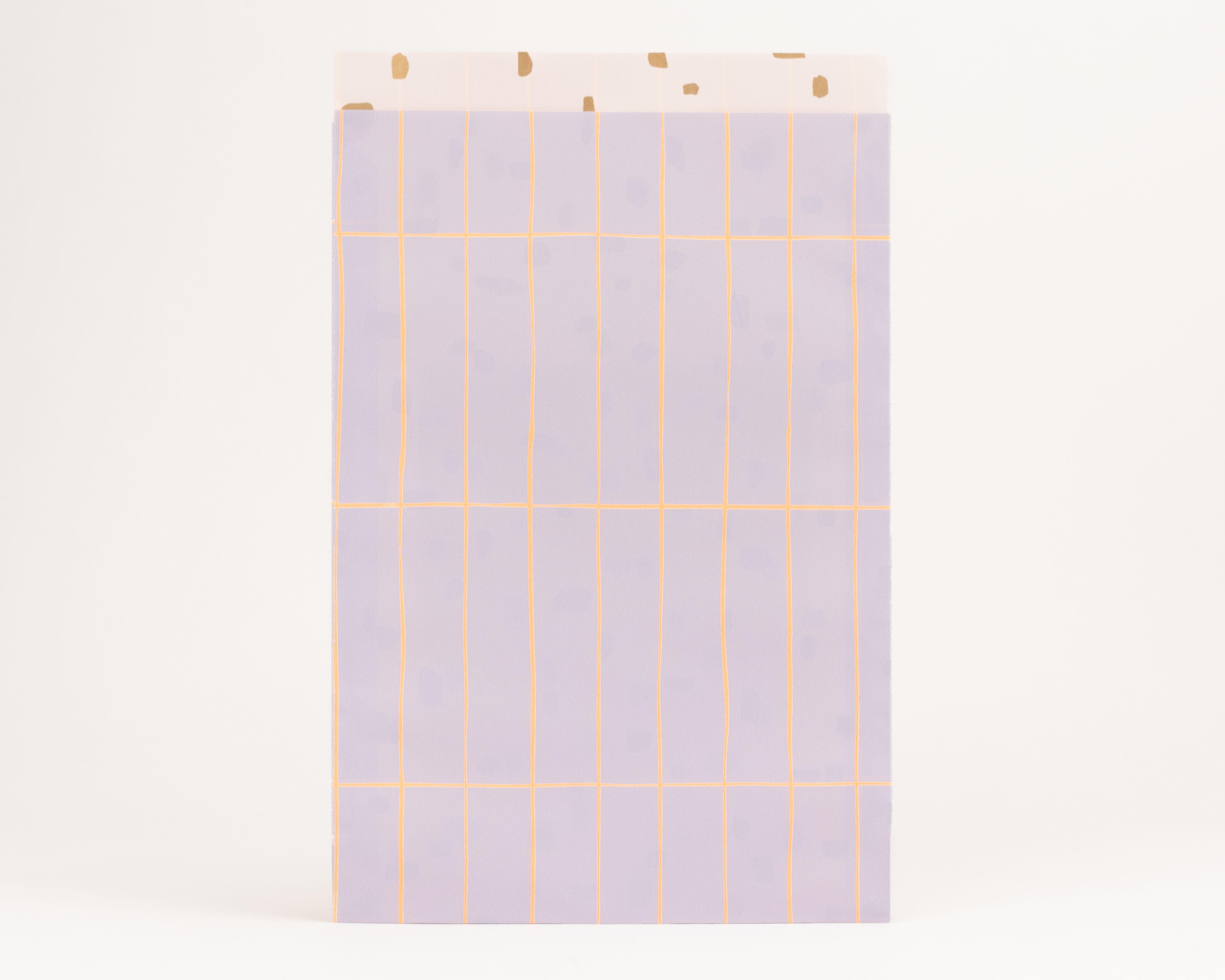 Flachbeutel zeigen eine lila Außenseite mit einem orangefarbenen Rastermuster. Die Innenseite ist hellbeige mit unregelmäßigen goldfarbenen Punkten