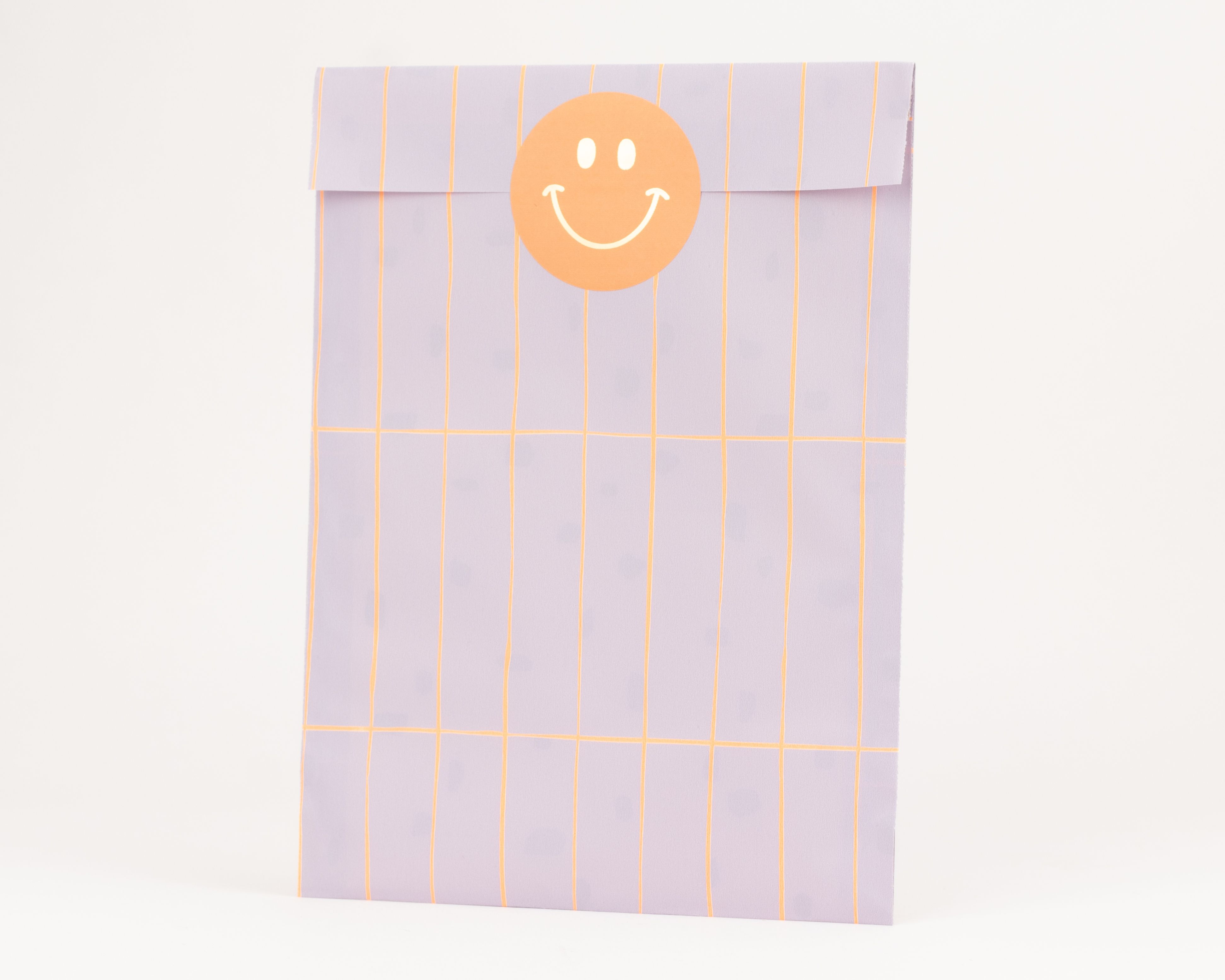 Flachbeutel in Flieder mit Rastermuster in Neon Orange und farblich passender Innenseite, mit einem orangefarbenen Smiley Aufkleber