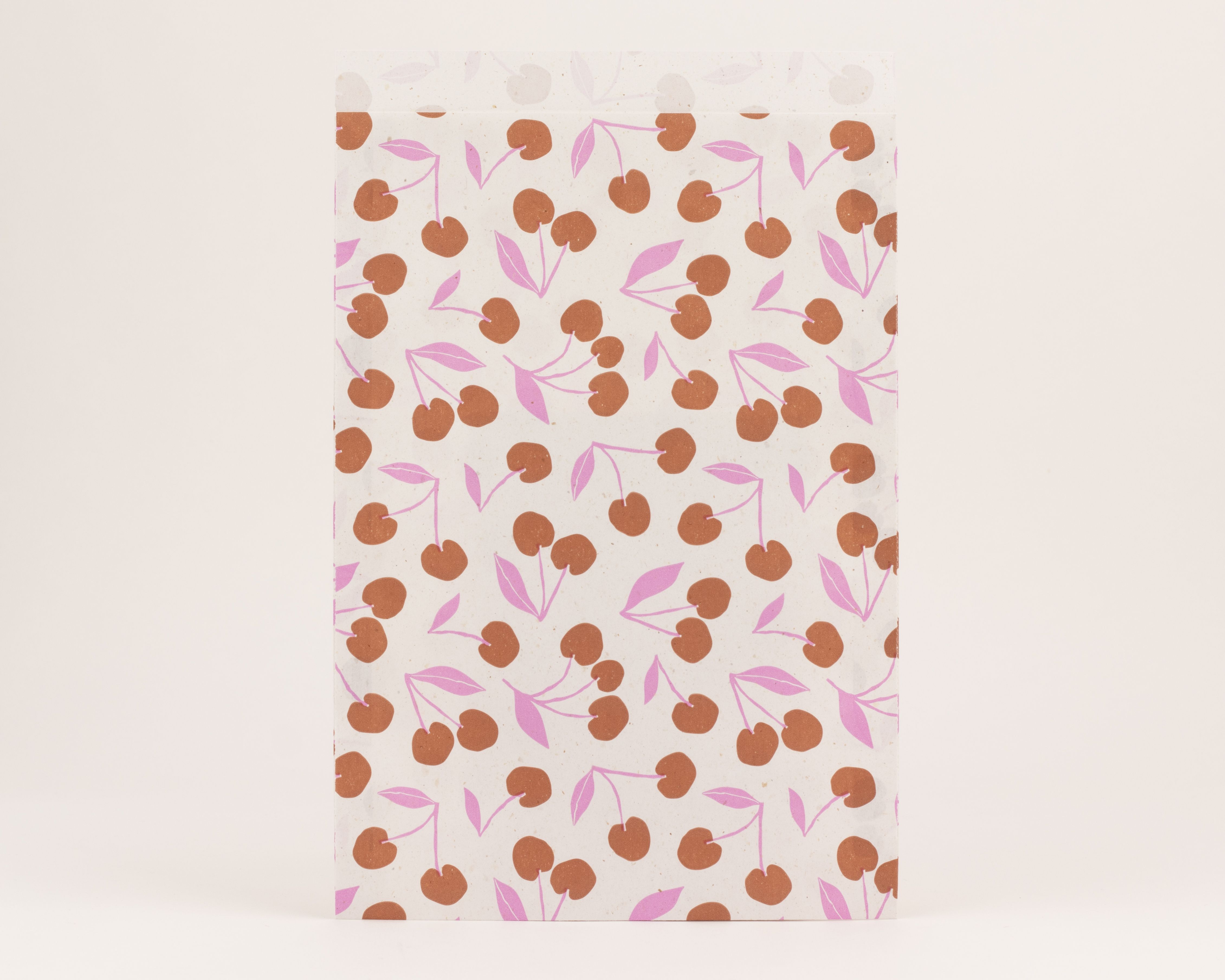 Flachbeutel mit einem Retro Kirschmuster in Braun und Pink Die Innenseite der Tüte ist in einem schlichten hellen Farbton gehalten