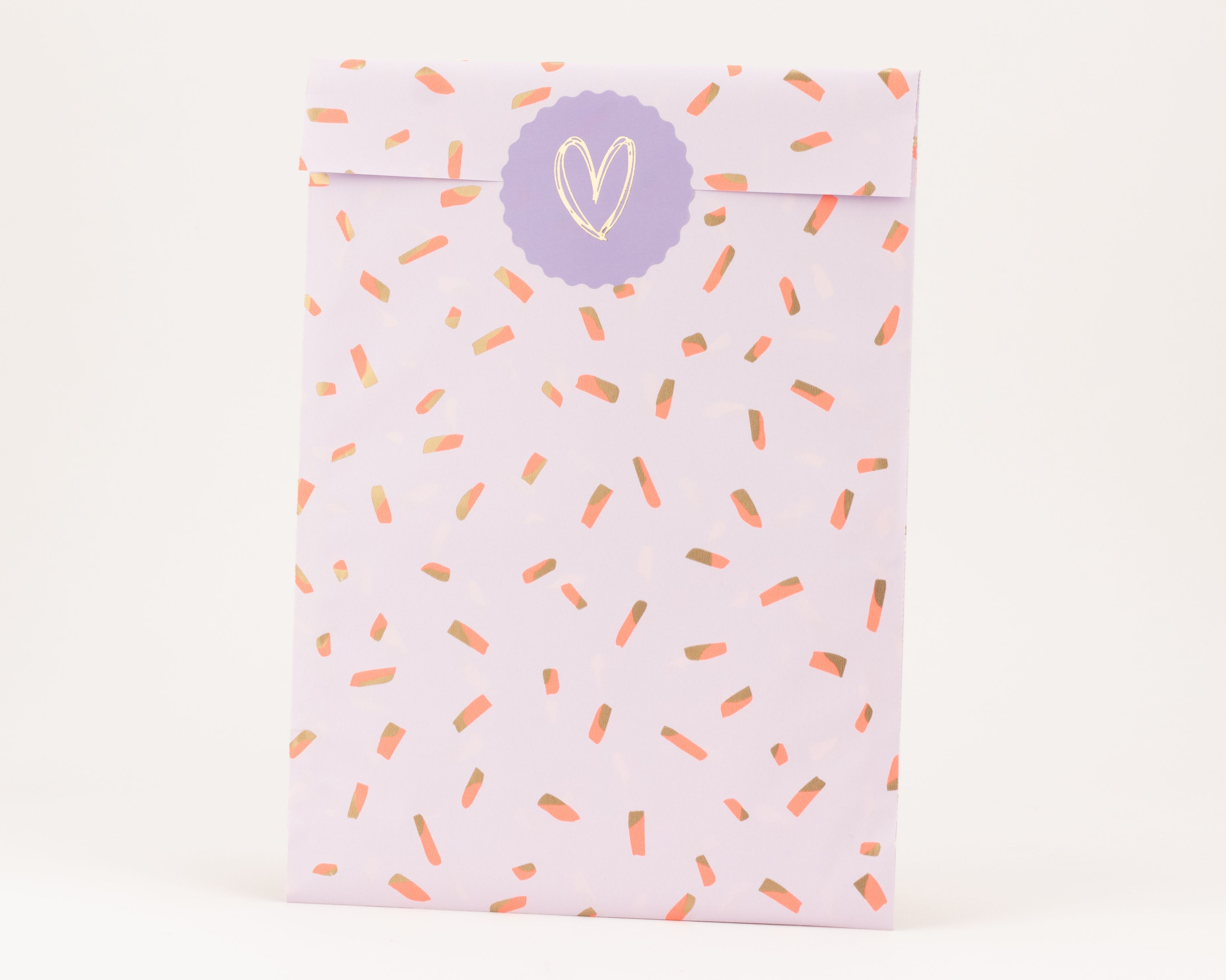 Flachbeutel in hellem Flieder mit einem Muster aus korallenfarbenen und goldenen Sprinkles