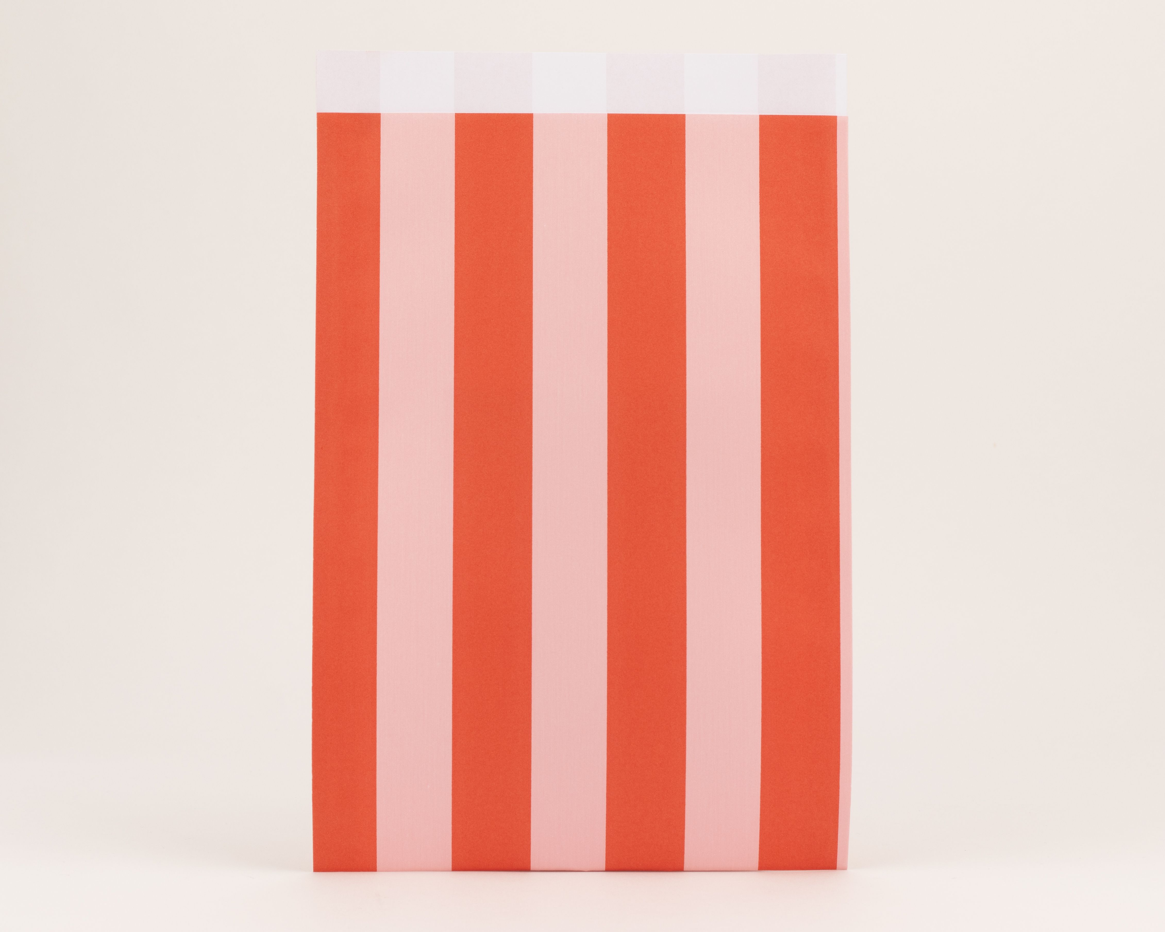 Flachbeutel mit einem vertikalen Streifenmuster in den Farben Rot und Rosa. Die Innenseite ist weiß