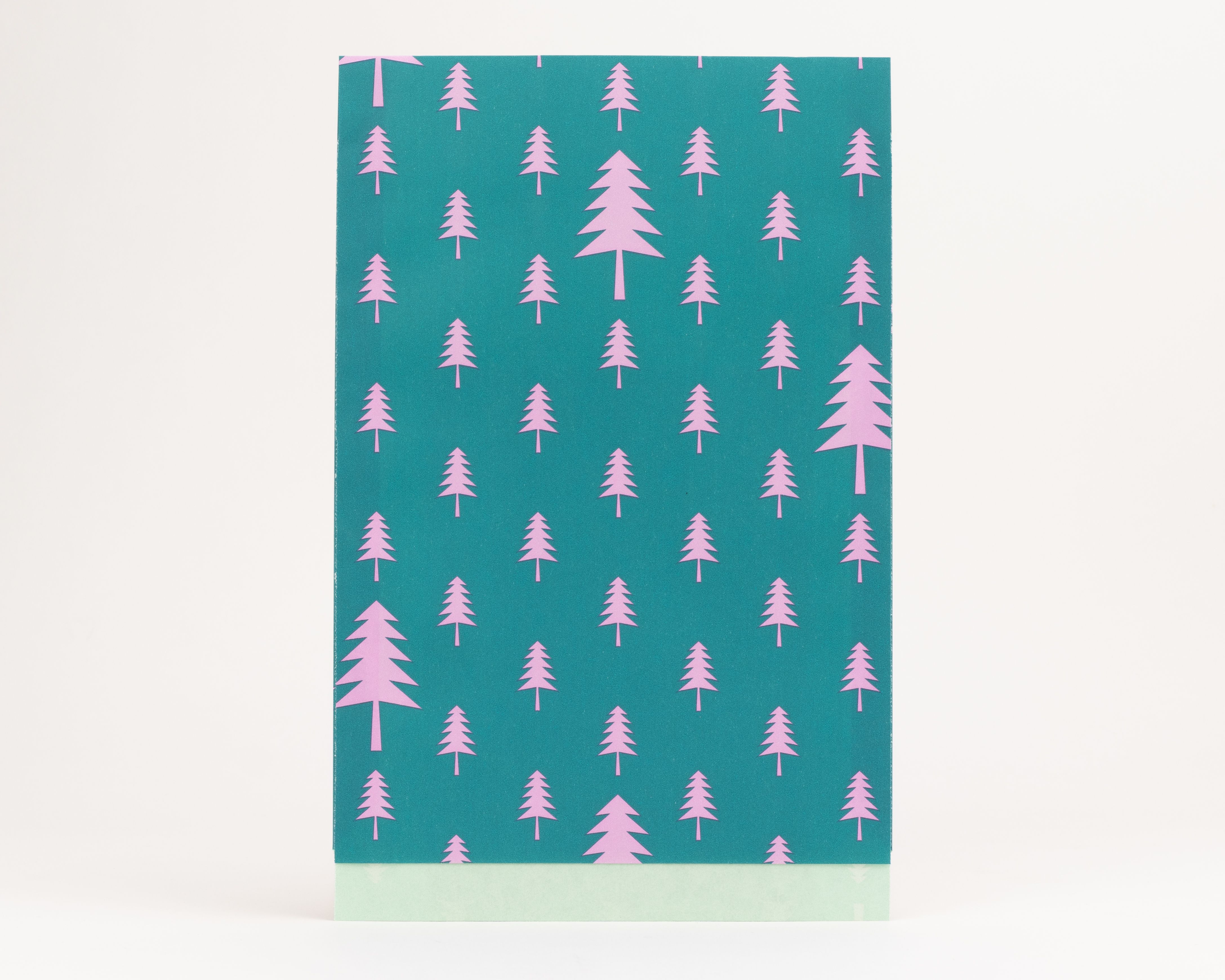 Flachbeutel mit einem grünen Außenbereich und einem pinken Tannenbaum-Muster, ergänzt durch eine hellgrüne Innenseite