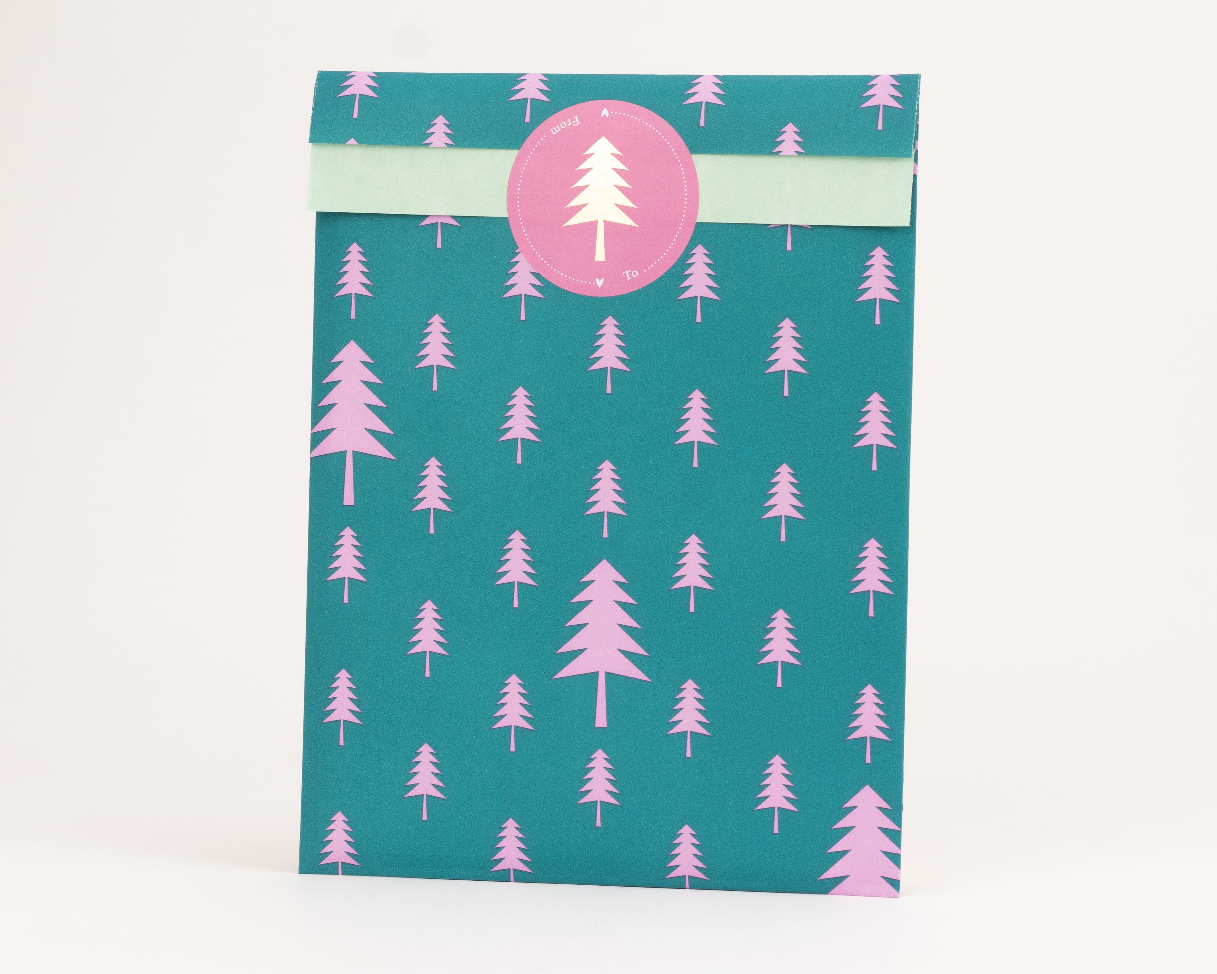 Flachbeutel mit grüner Außenseite und rosa Tannenbaum-Muster, die Innenseite ist hellgrün