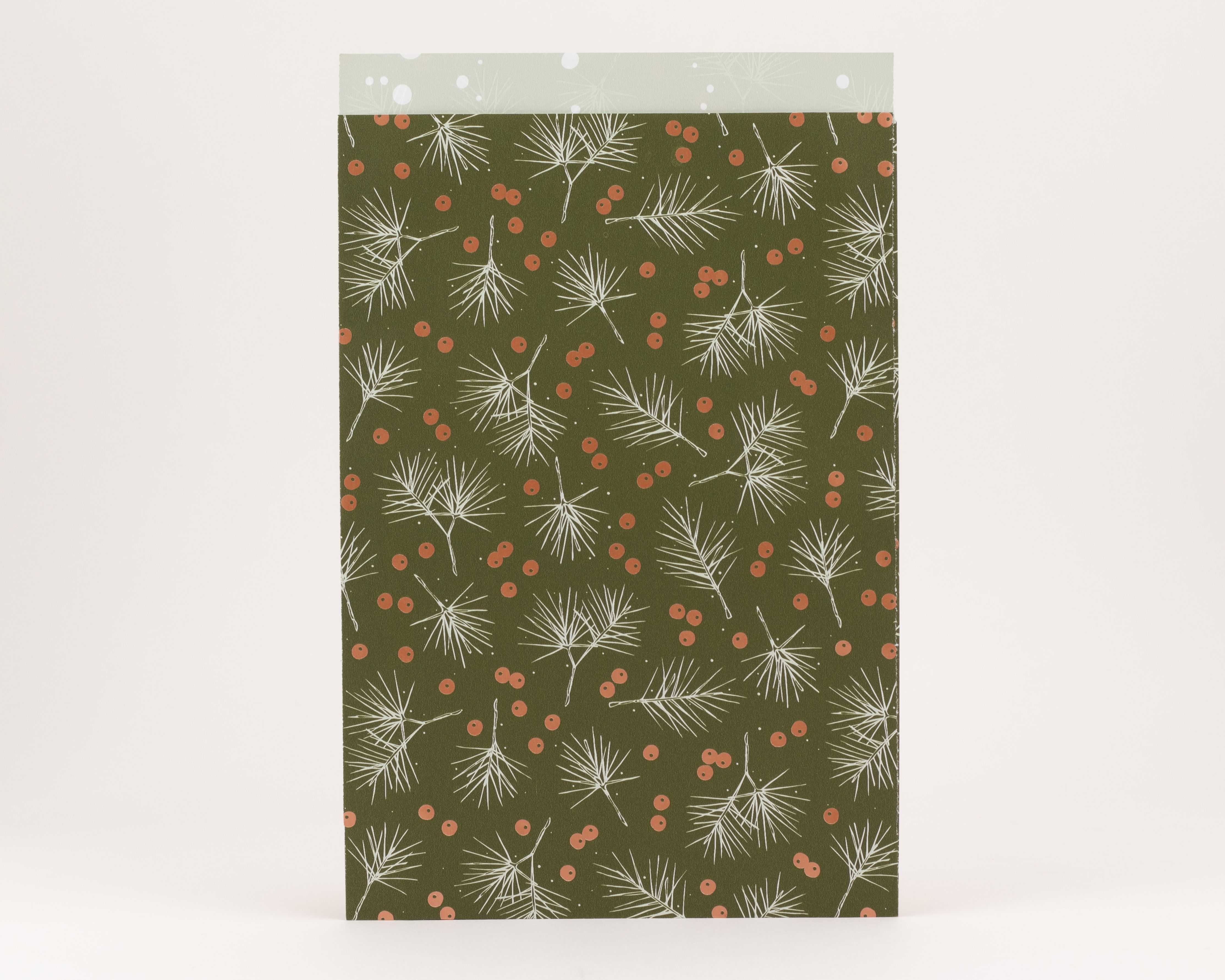 Flachbeutel in Olivgrün mit weißen Tannenästen und glänzenden korallenrosa Beeren, Innenseite hellgrün mit weißen Sprenkeln