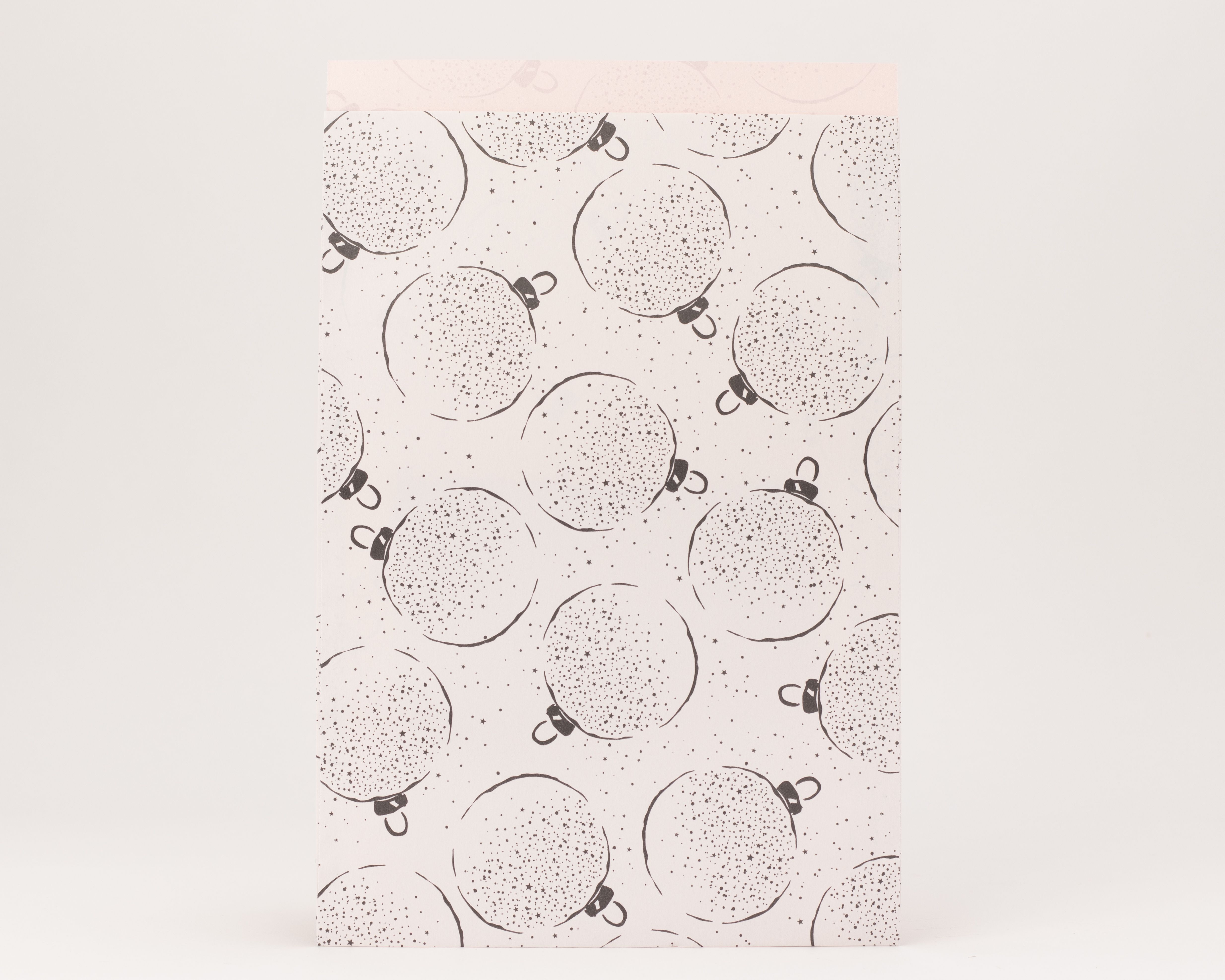 Flachbeutel mit grauem Weihnachtskugelmuster und kleinen Sternen, die Innenseite ist in zartem Rosa gehalten