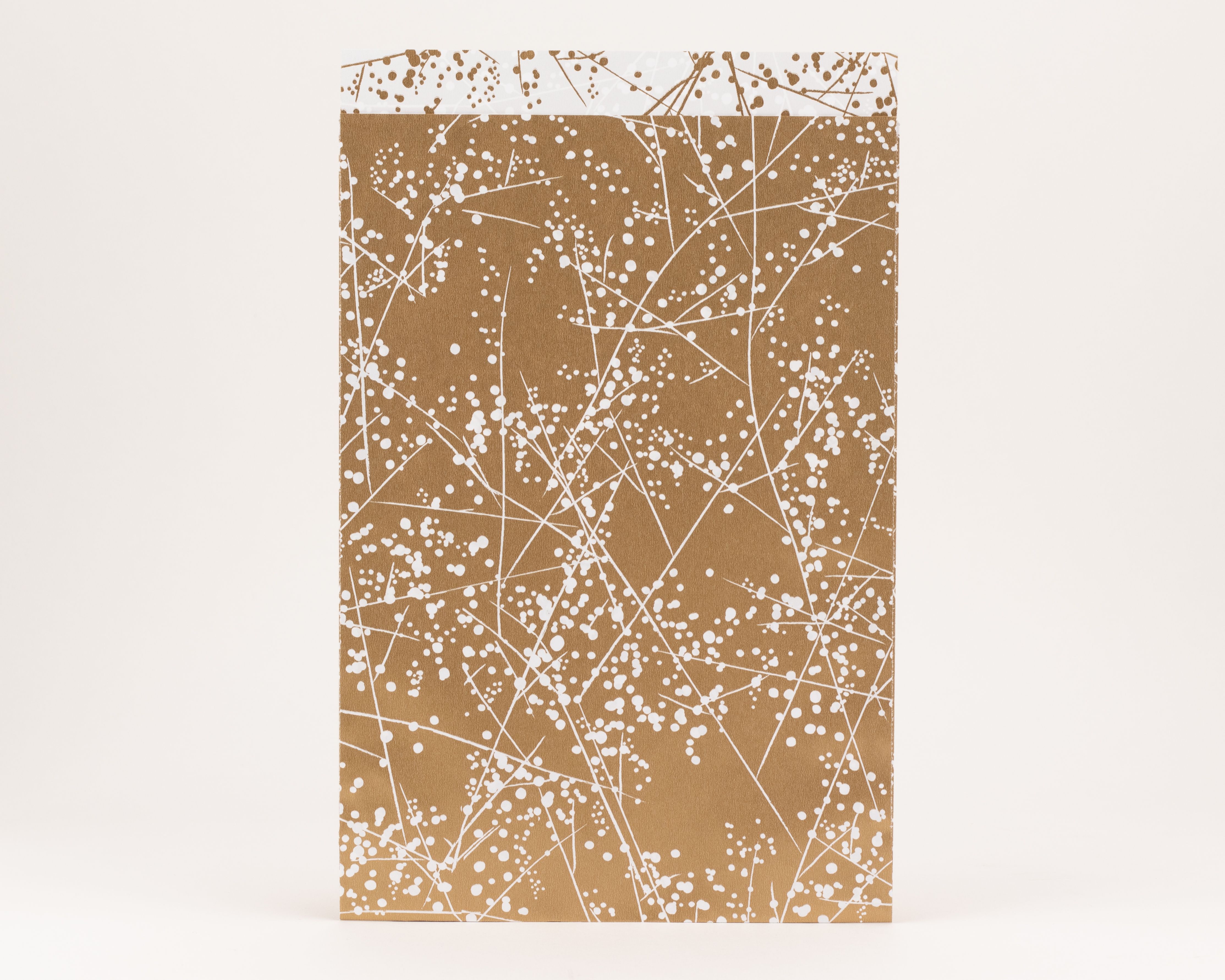 Flachbeutel mit goldener Außenseite und weißem Winterfrost-Muster. Die Innenseite zeigt ein weißes Design mit goldenen Verzierungen