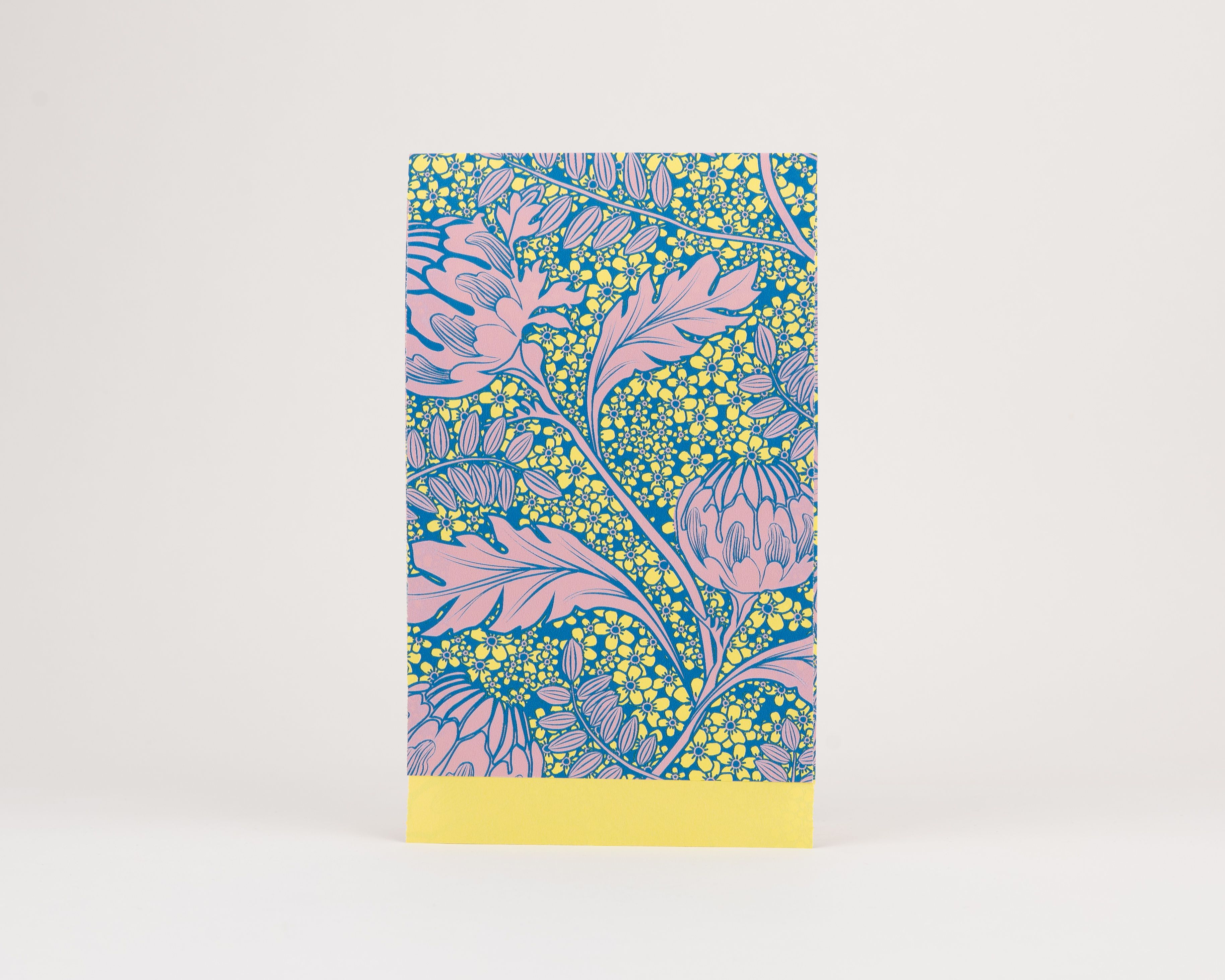 Papiertüten Flachbeutel zeigen ein florales Artischockenmuster in Rosa, Blau und Gelb. Die Innenseite ist einfarbig Gelb