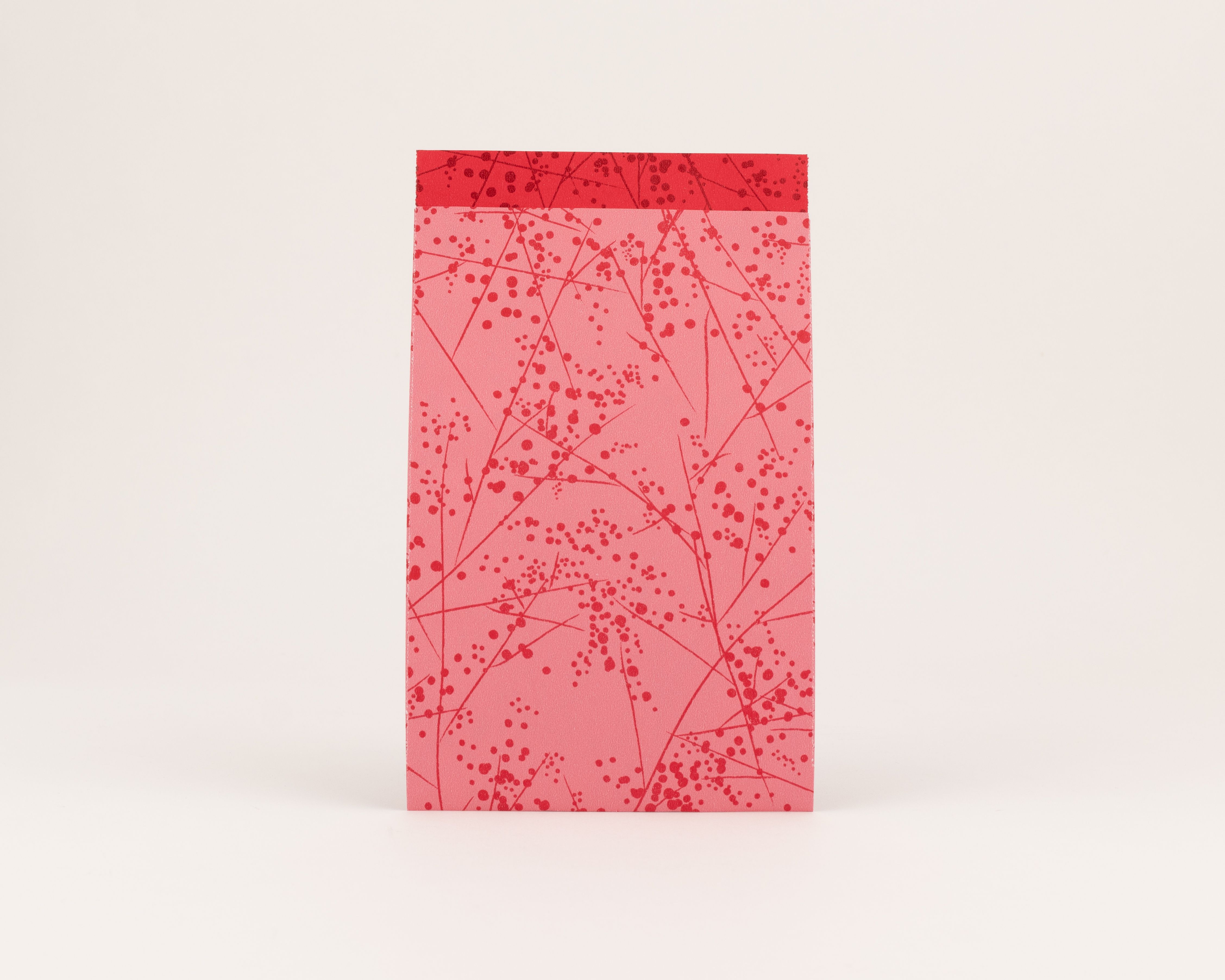 Flachbeutel mit einem roten Verzweigungsmuster auf pinker Außenseite und einer einfarbigen roten Innenseite.