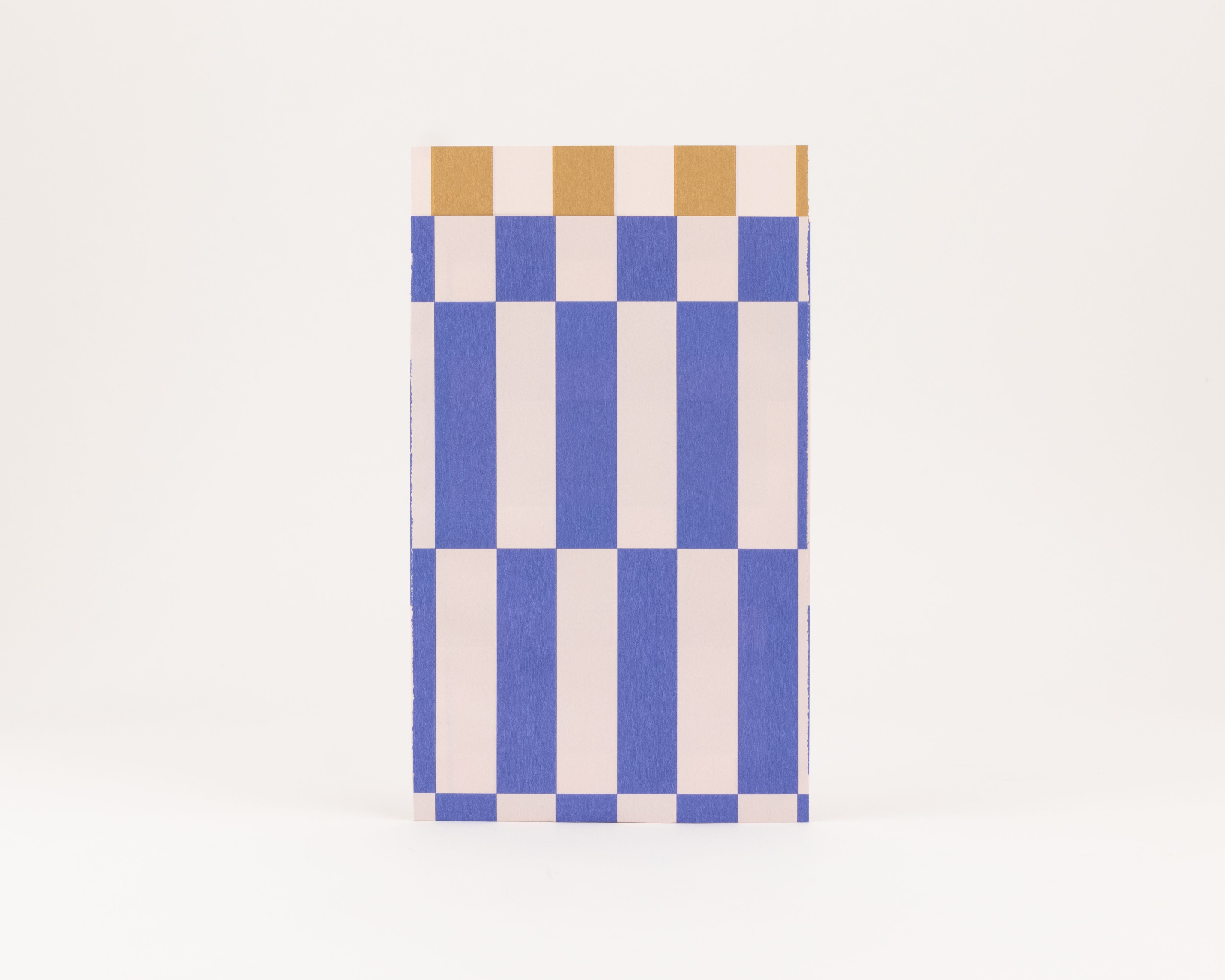 Flachbeutel mit blauem und elfenbeinfarbenem Streifen- und Karomuster. Die Innenseite zeigt ein weißes und ockerfarbenes Blockmuster
