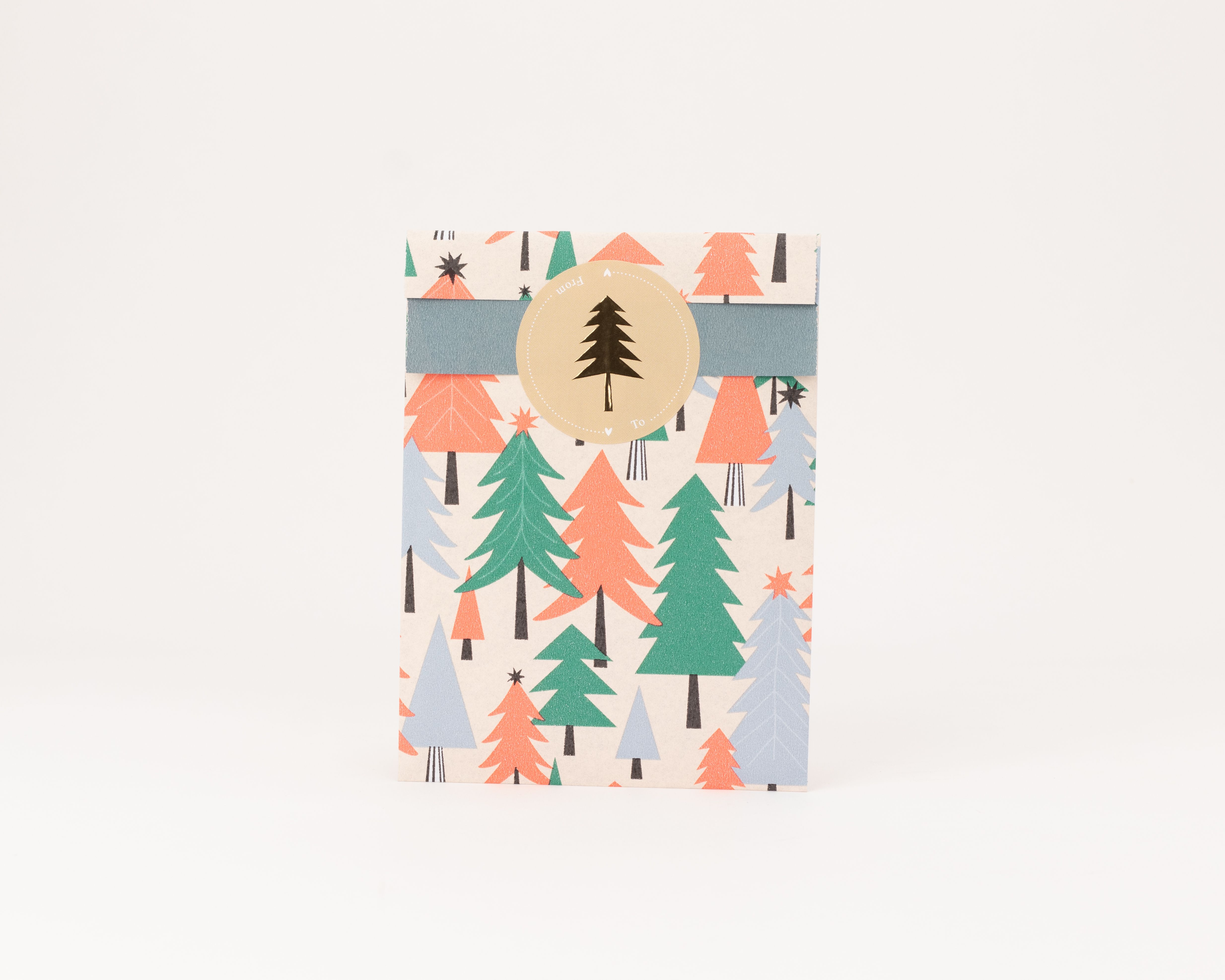 Flachbeutel mit buntem Baummuster in Grün, Neon Orange und Blau auf Elfenbein. Die Innenseite ist Blau, ergänzt durch einen runden Aufkleber mit Baum-Motiv