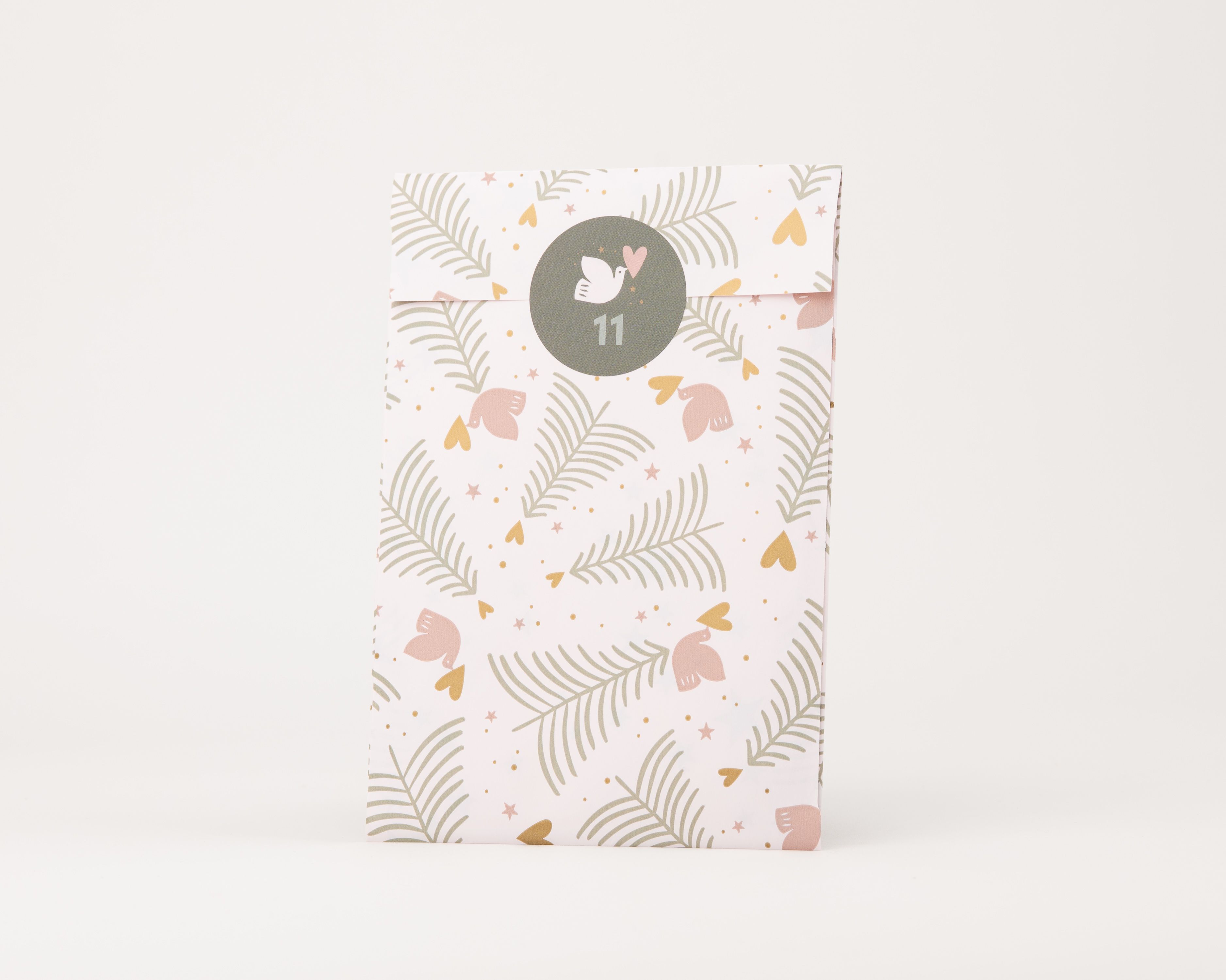 Papiertüten Flachbeutel mit einem Muster aus grünen Tannen, rosa Vögeln, goldenen Herzen und Pünktchen auf puderrosa Grund