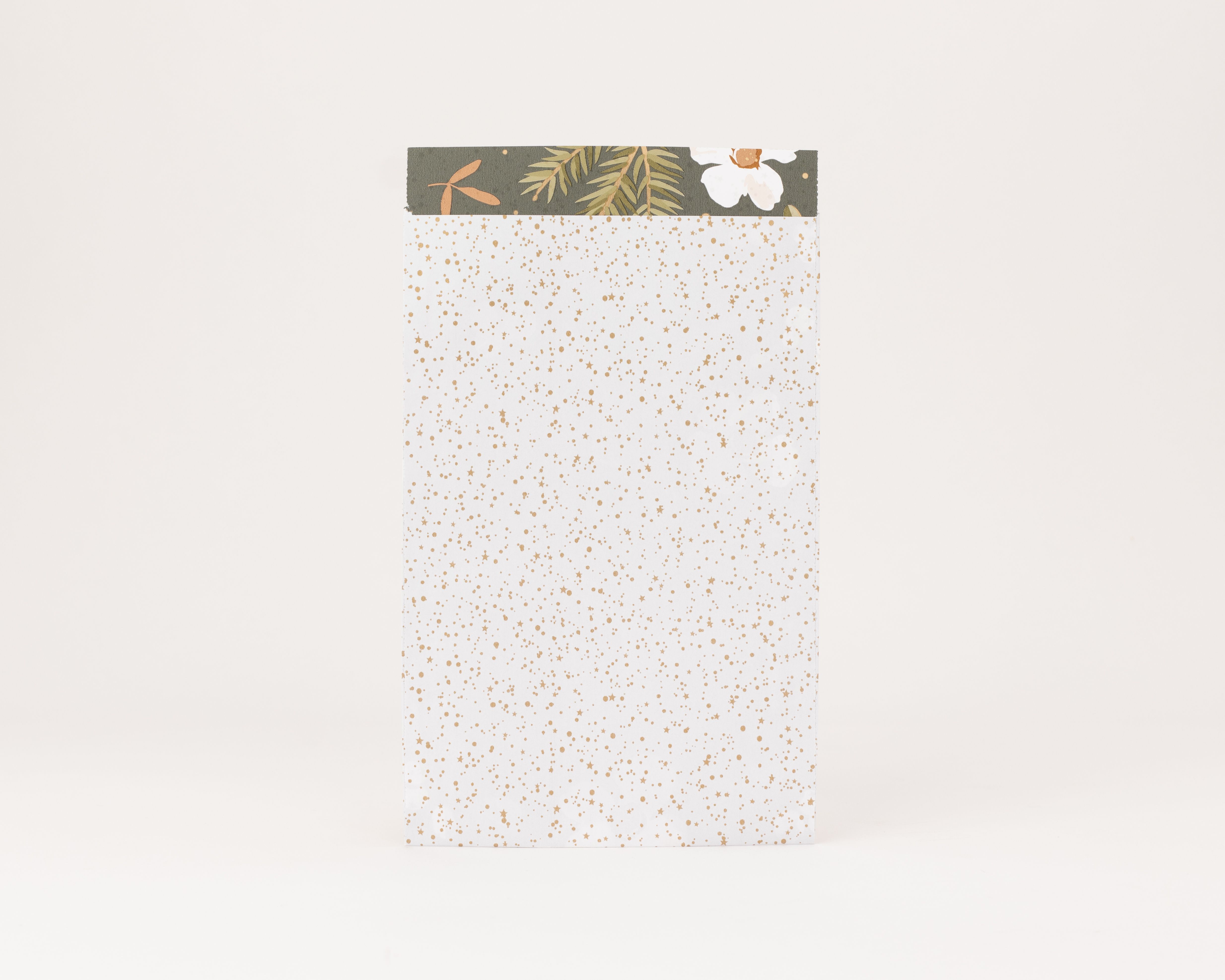 Flachbeutel weiß mit funkelnden goldenen Sternen und Punkten, Innenseite dunkelgrün mit goldenen Blättern und weißer Blüte
