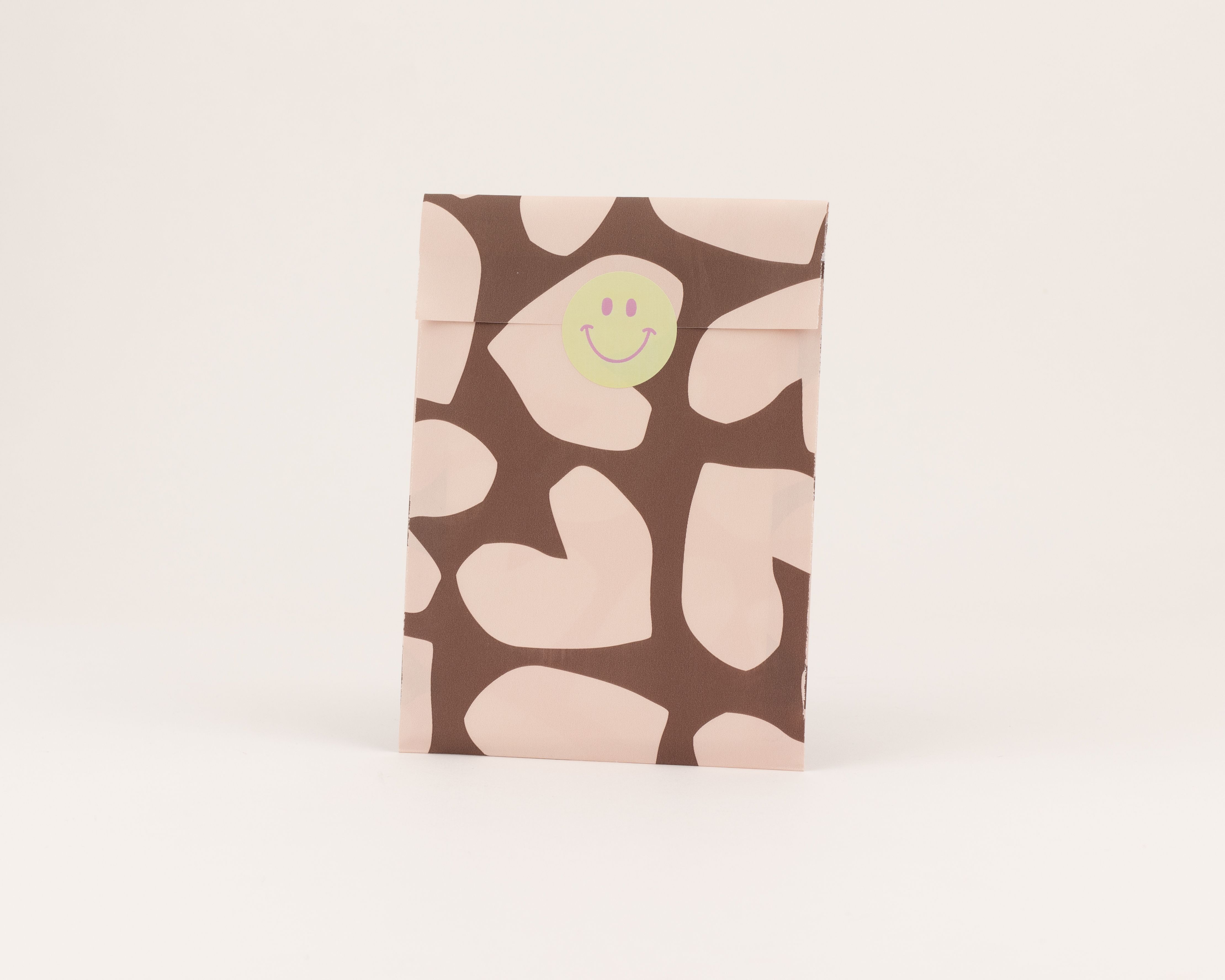 Flachbeutel zeigen ein braunes Design mit beigen Herzformen auf der Außenseite. Die Innenseite der Papiertüten ist ebenfalls beige