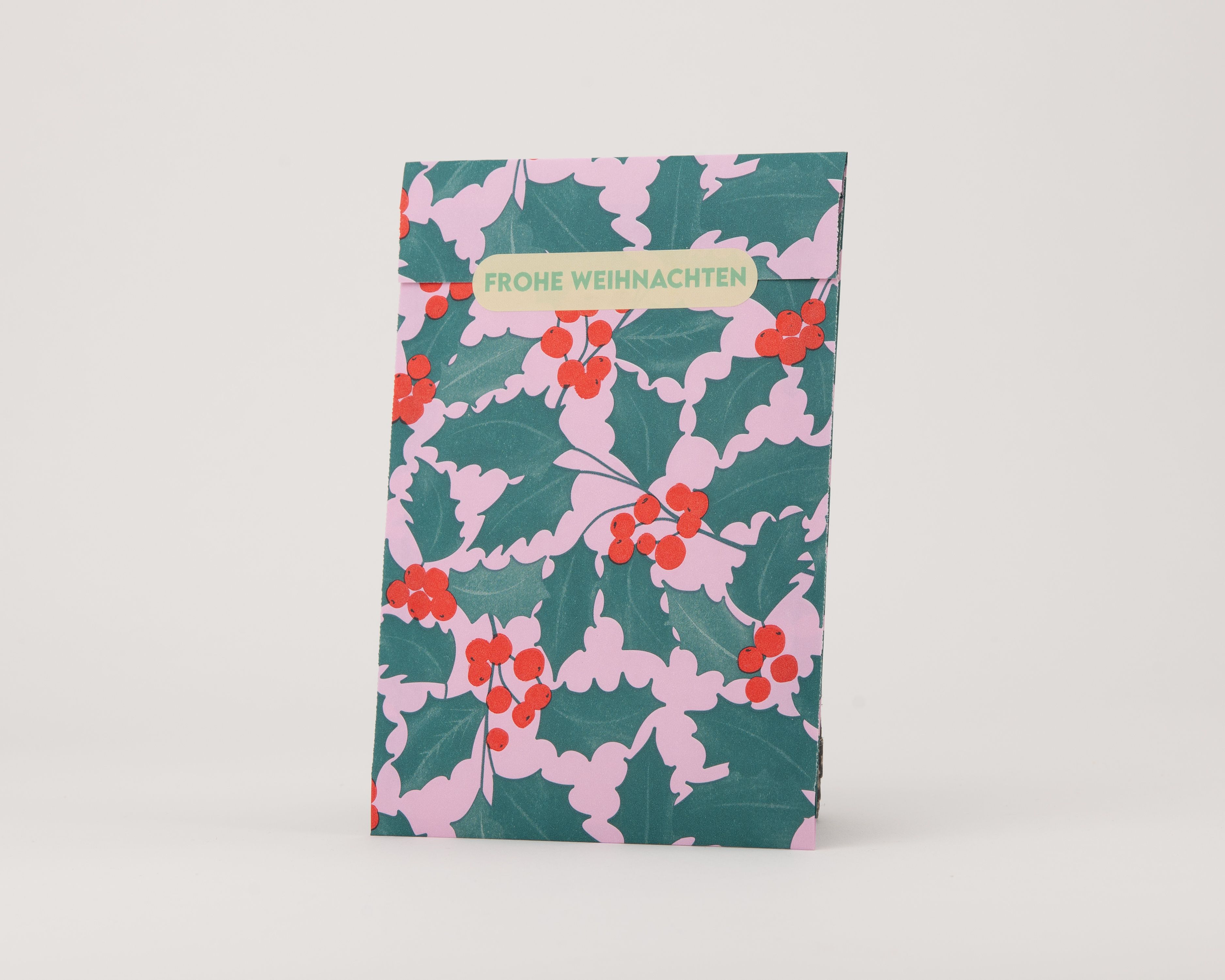Papiertüten Flachbeutel mit einem Ilex-Muster in Grün auf rosa Hintergrund und beigefarbener Innenseite