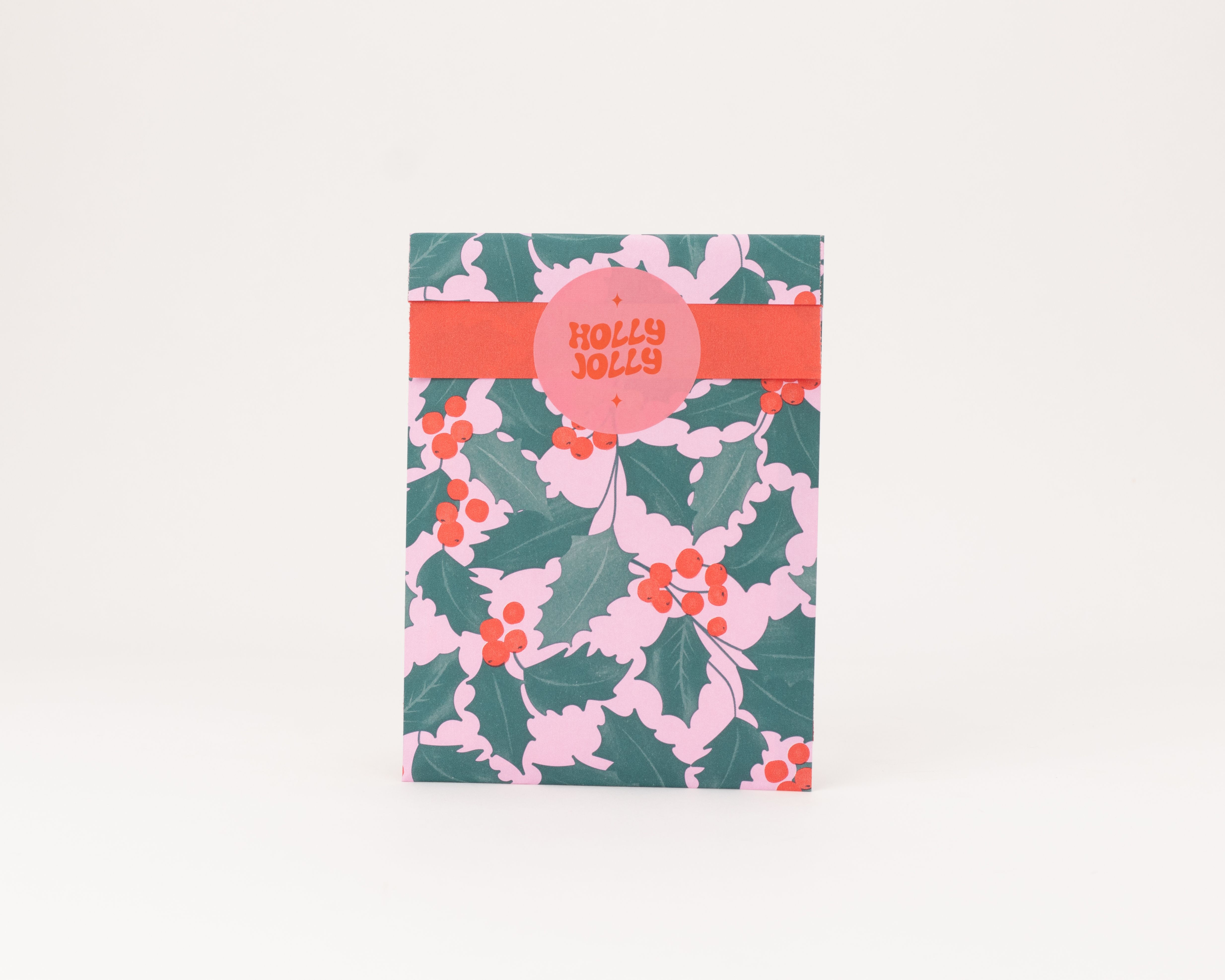 Flachbeutel mit einem Ilex-Muster in Rosa und Grün und roten Beeren, die Innenseite ist einfarbig rot