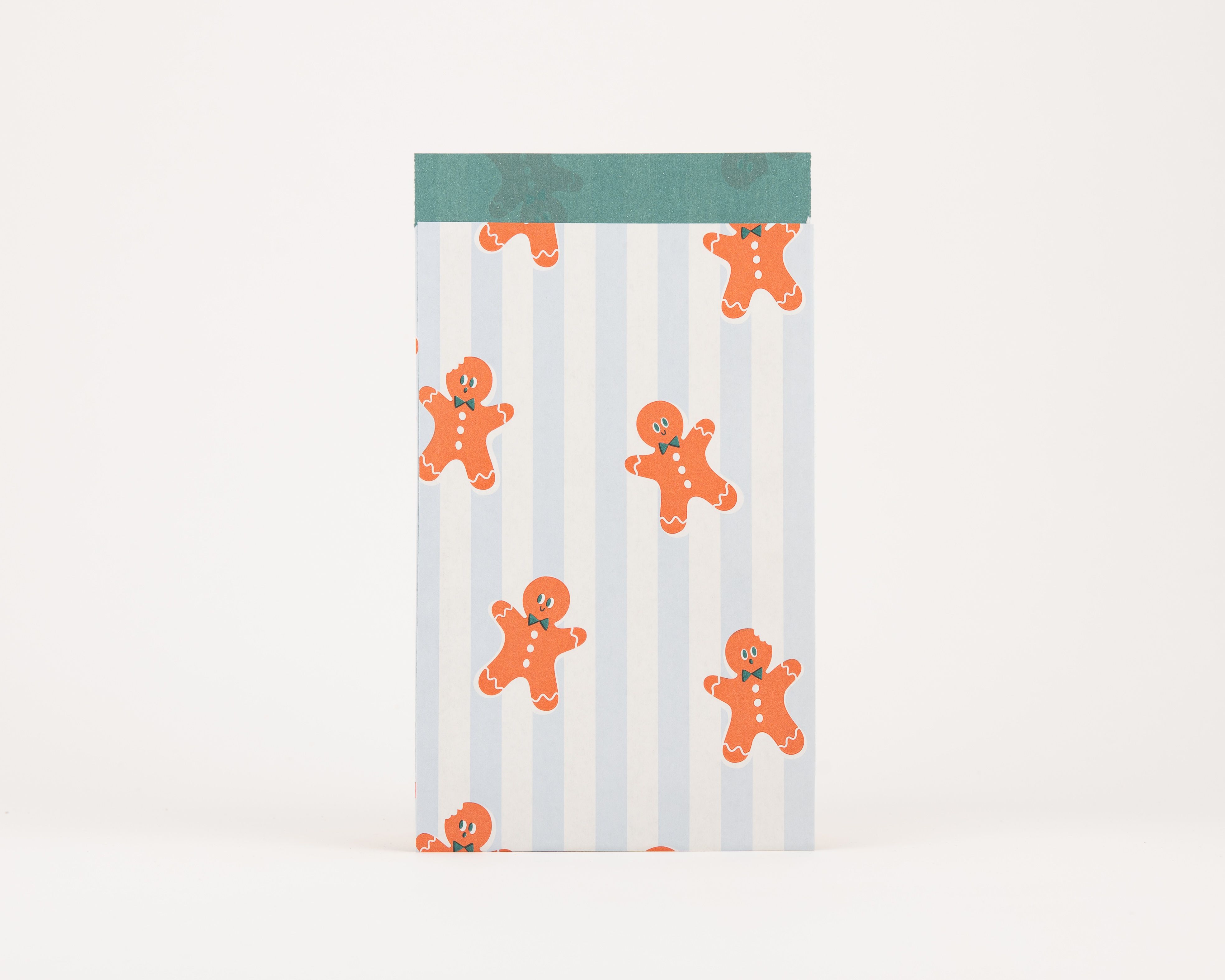 Papiertüten Flachbeutel mit einem blau-weiß gestreiften Muster und orangefarbenen Lebkuchenmännchen. Die Innenseite ist in Grün gehalten