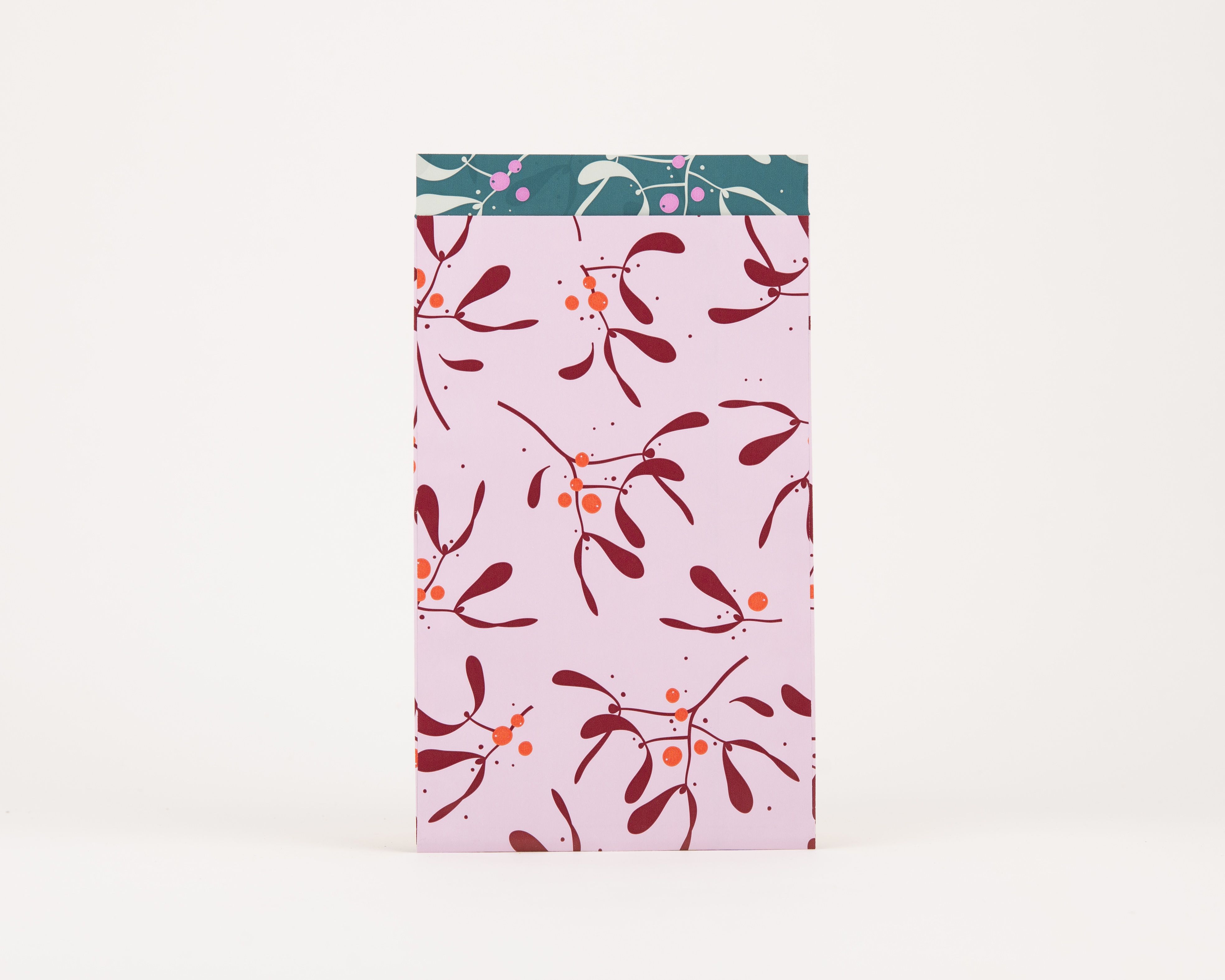 Papiertüten Flachbeutel, außen hellrosa mit weinroten Mistelzweigen und orangen Beeren. Innen petrolfarben mit weißem Muster und Magenta-Punkten