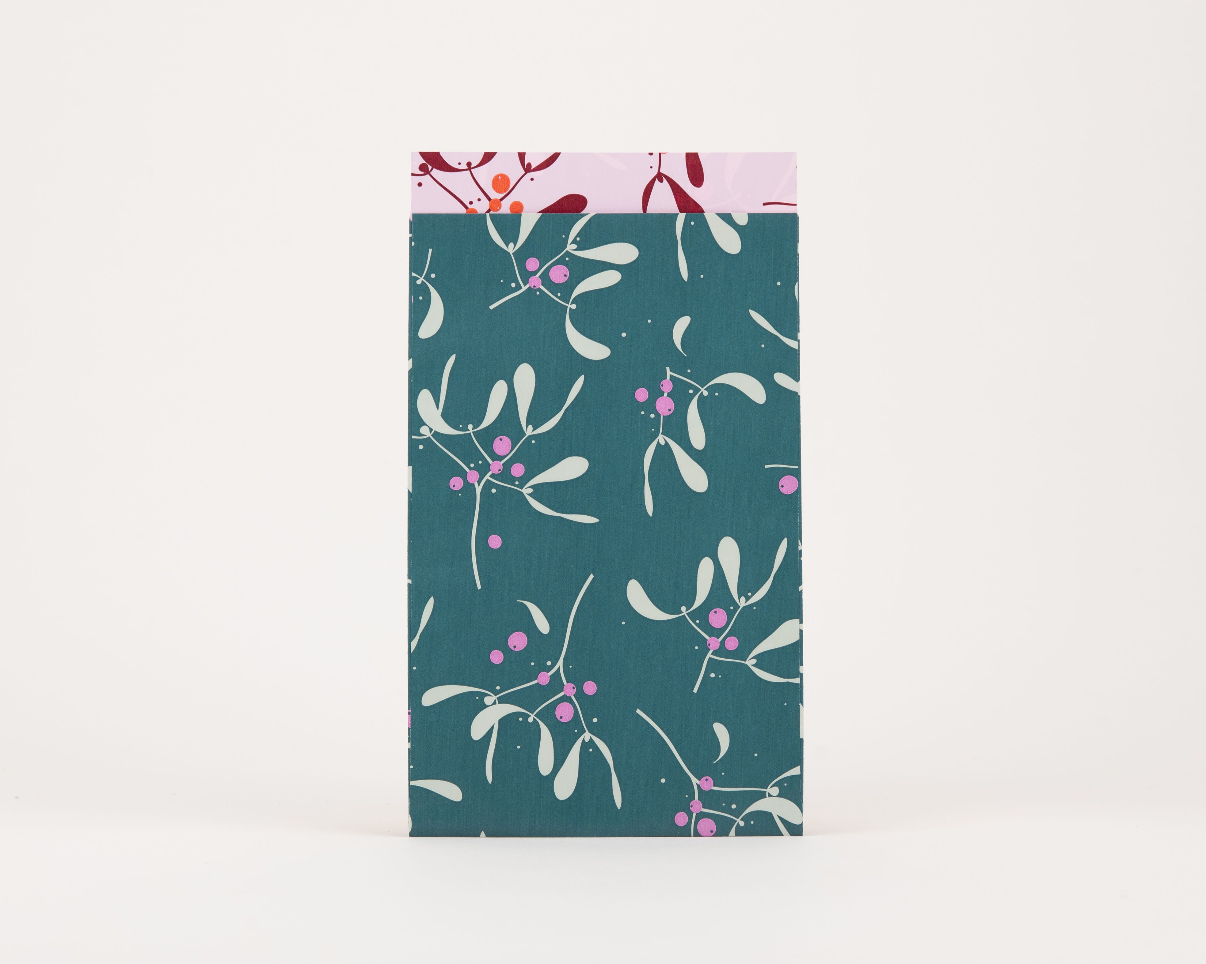 Papiertüten Flachbeutel mit einem Mistelzweig-Muster in Petrol, Hellgrün und Magenta auf der Außenseite, und einer Innenseite in Rosa mit weinrotem Muster