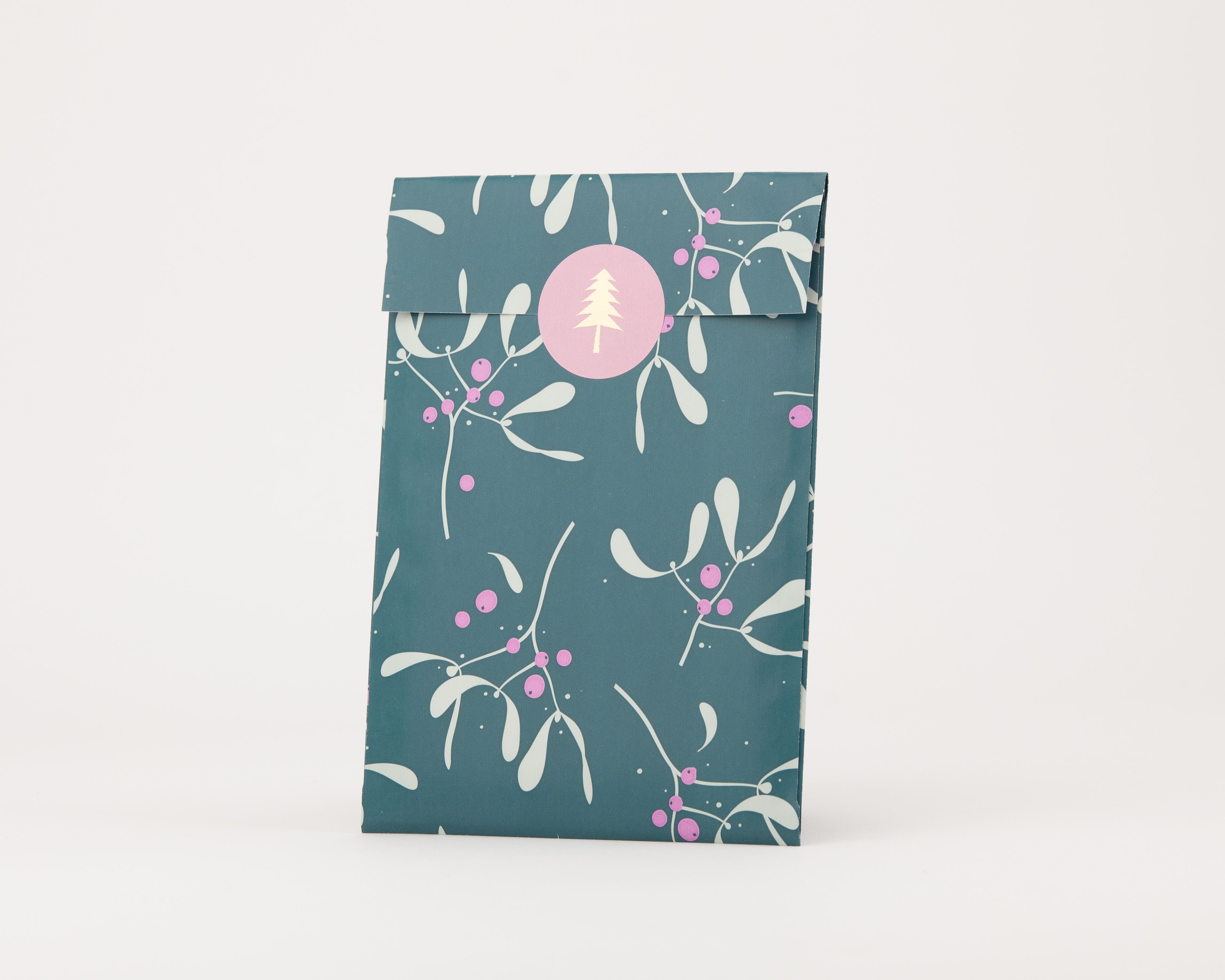 Papiertüten Flachbeutel Petrol mit Mistelzweig Muster Hellgrün und Magenta, ein runder rosafarbener Sticker mit Weihnachtsbaum