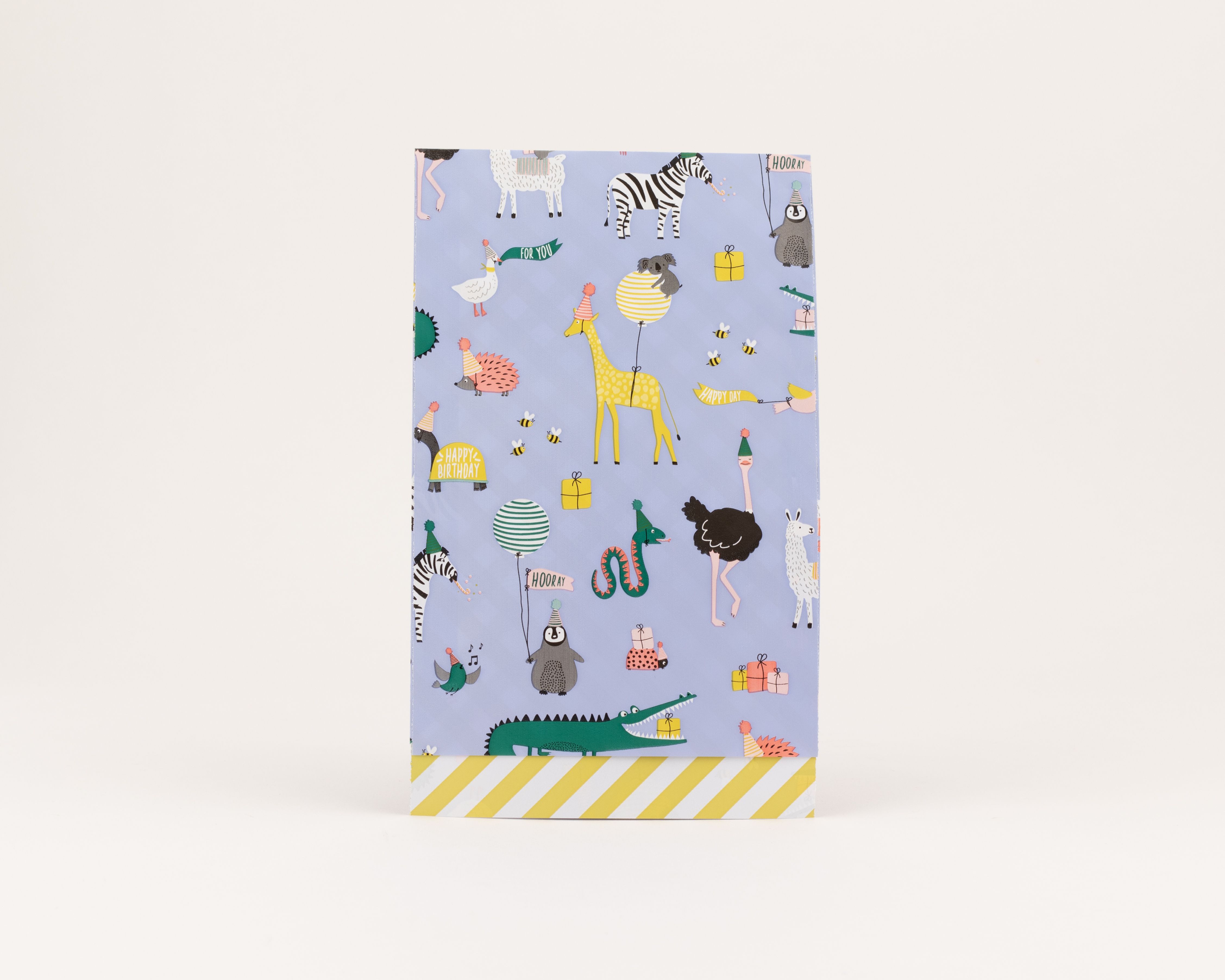 Flachbeutel mit blauem Hintergrund und einem bunten Partytiere-Motiv Die Innenseite ist mit gelben und weißen Diagonalstreifen versehen