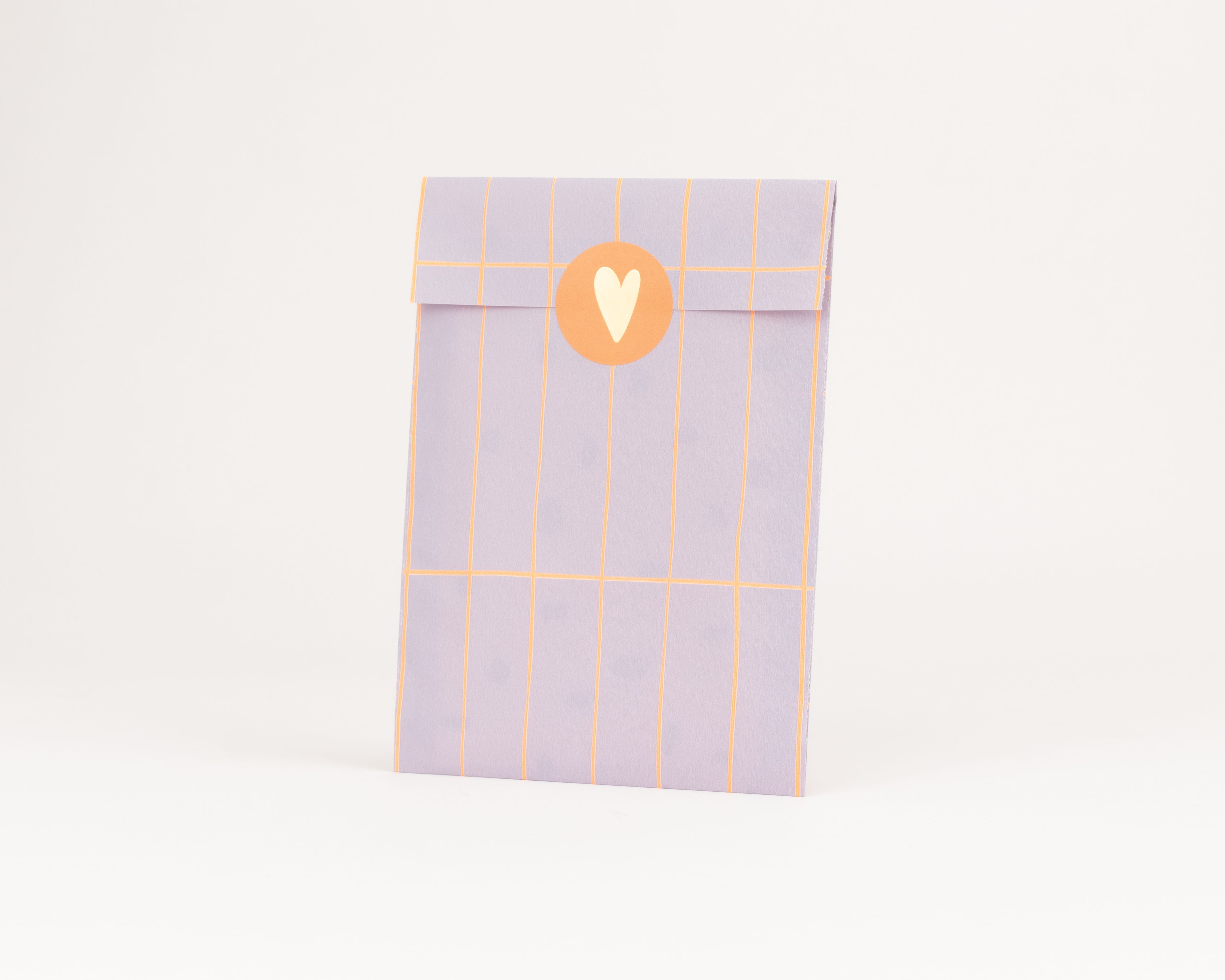 Flachbeutel in Flieder mit neonorangem Rastermuster. Die Innenseite ist schlicht fliederfarben. Ein runder, oranger Aufkleber mit hellem Herz