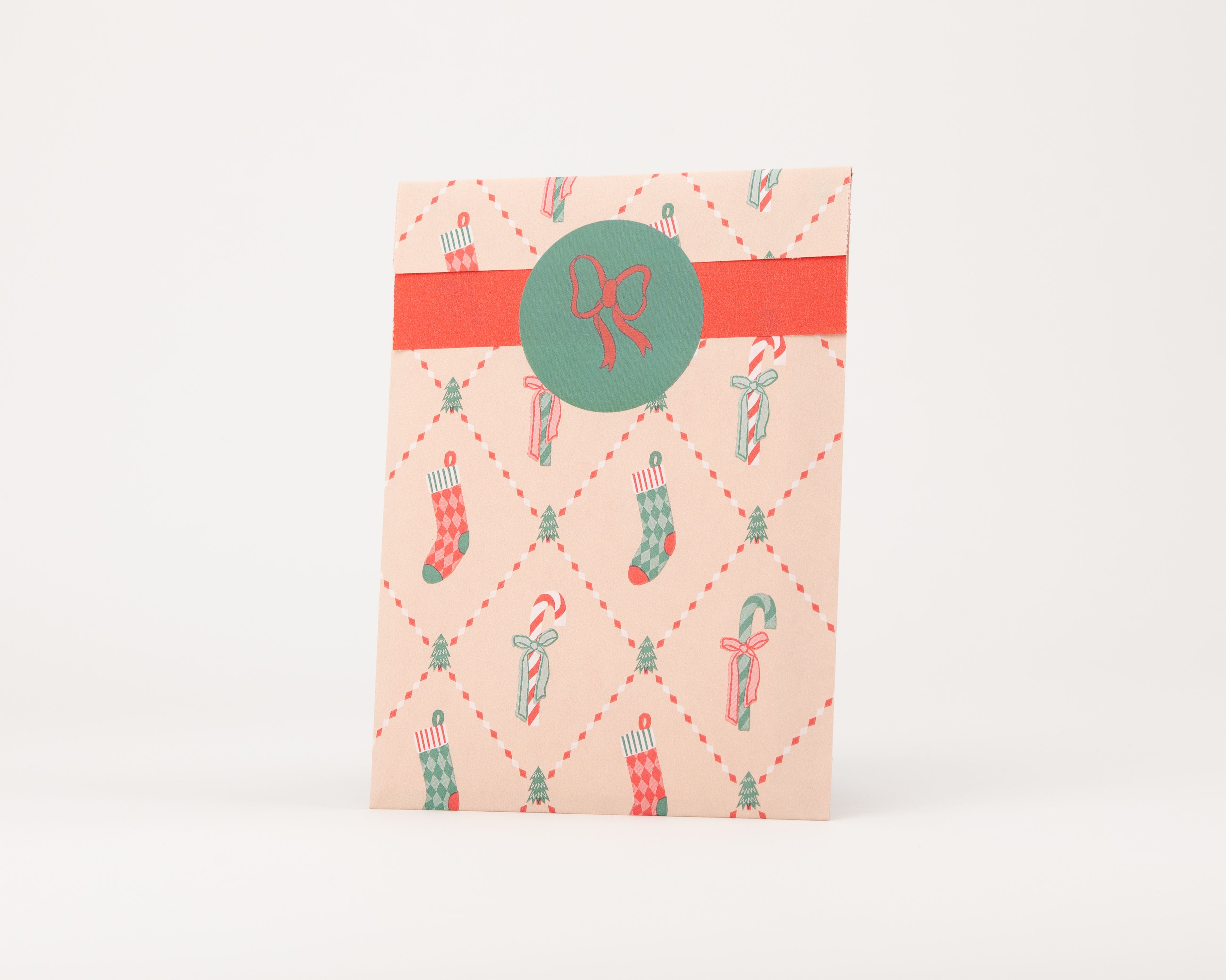 Papiertüten Flachbeutel im Retro Weihnachtsdesign in Beige mit Motiven in Rot und Grün. Die Innenseite ist ebenfalls Beige mit Muster.