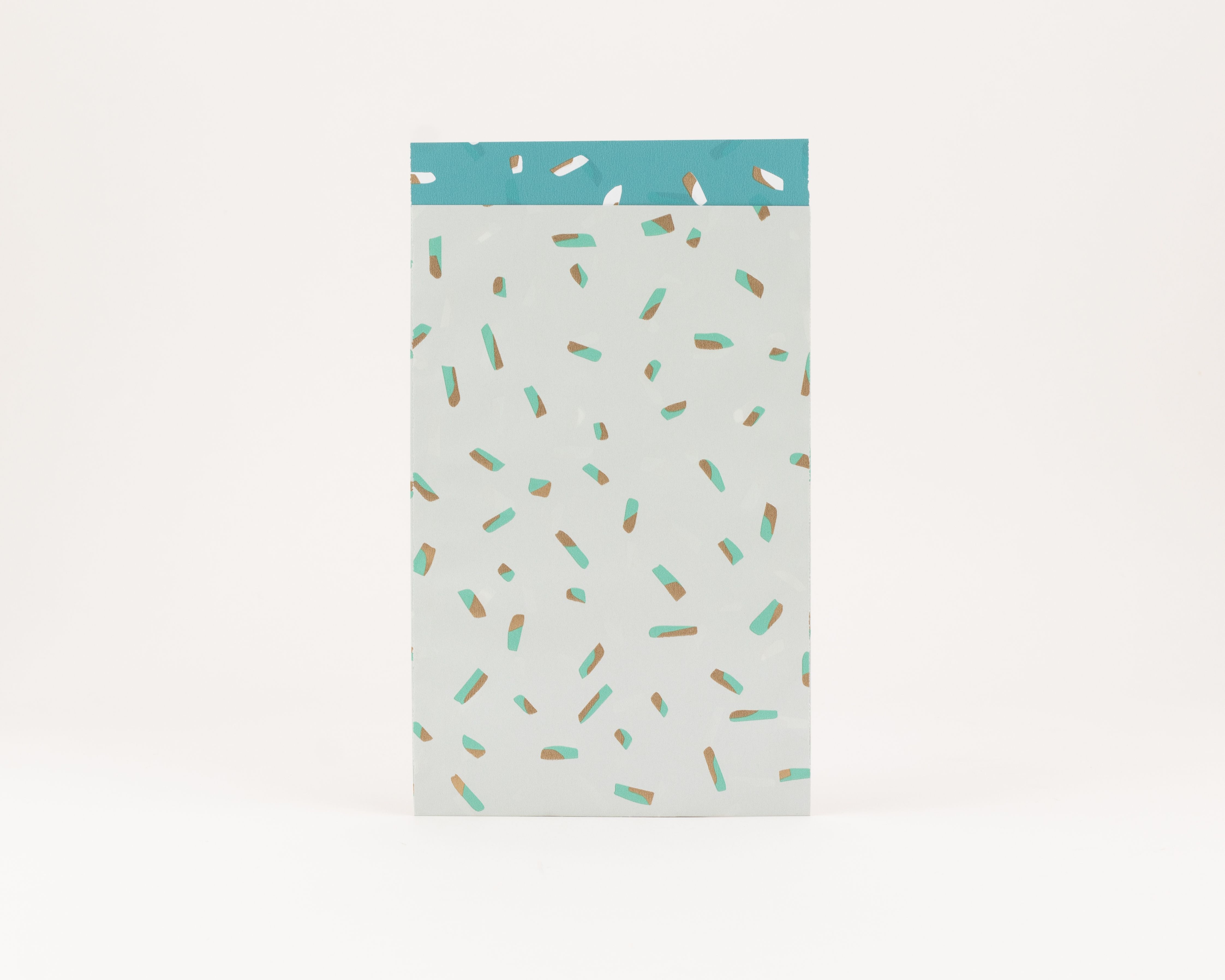 Flachbeutel mit einem salbeigruenen Hintergrund und Sprinkles in Tuerkis sowie glaenzenden Goldtoenen, die Innenseite ist Tuerkis mit aehnlichen goldenen Akzenten