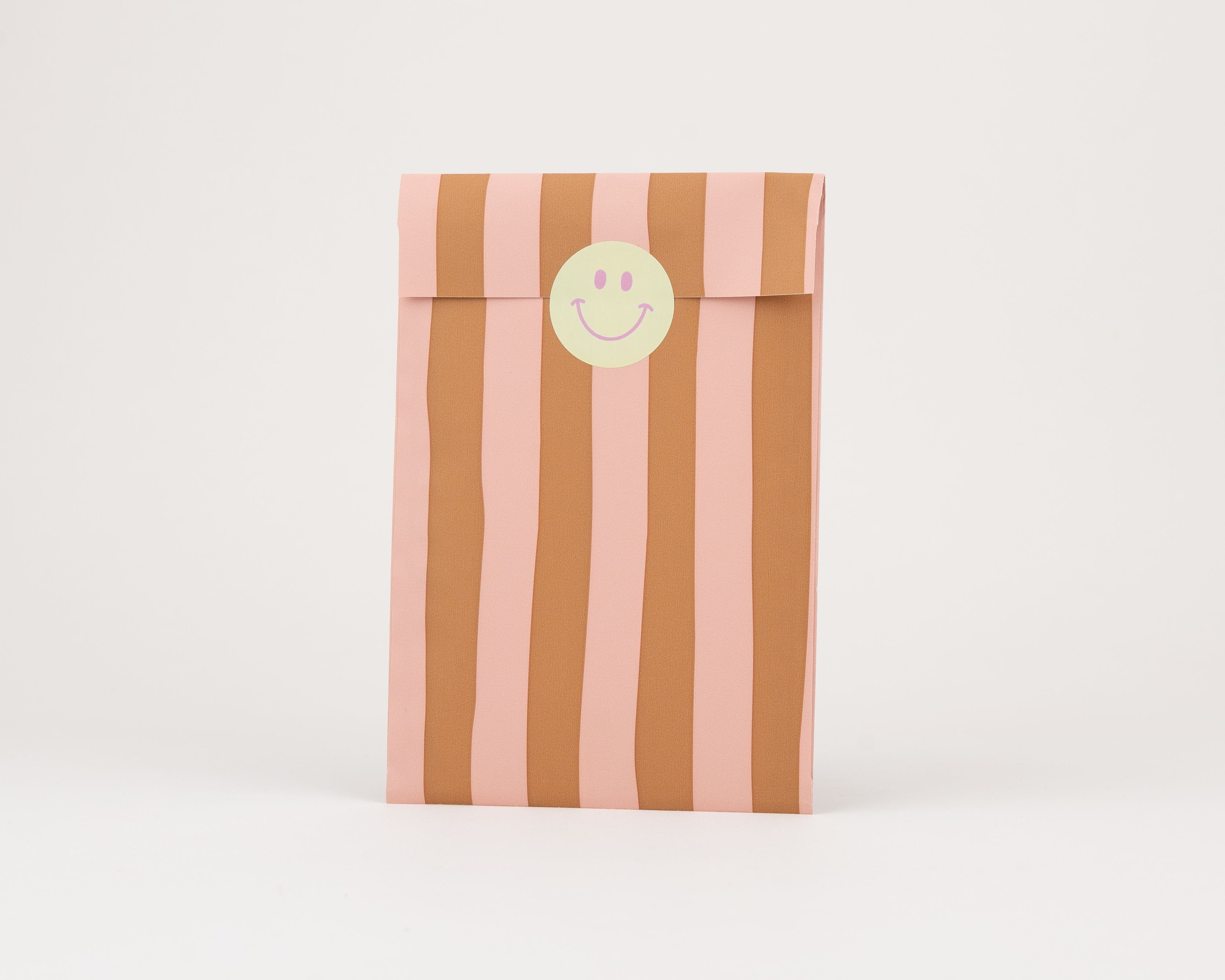 Papiertüten Flachbeutel im Streifenmuster in Rosa und Rost, verziert mit einem hellgrünen Smiley-Sticker