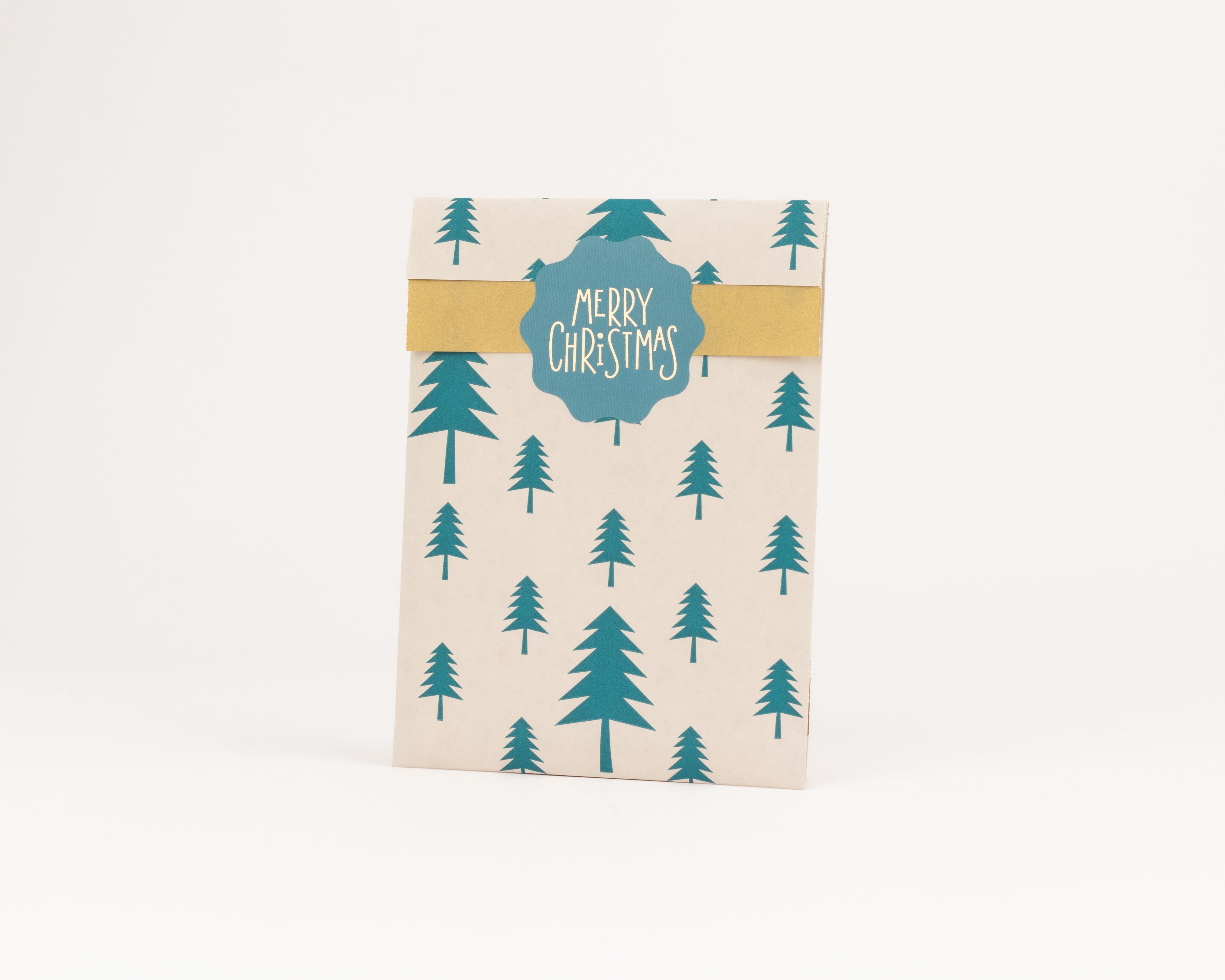 Flachbeutel mit beigem Hintergrund und grünen Tannenbäumen. Die goldene Innenseite ziert ein blaues Merry Christmas Etikett
