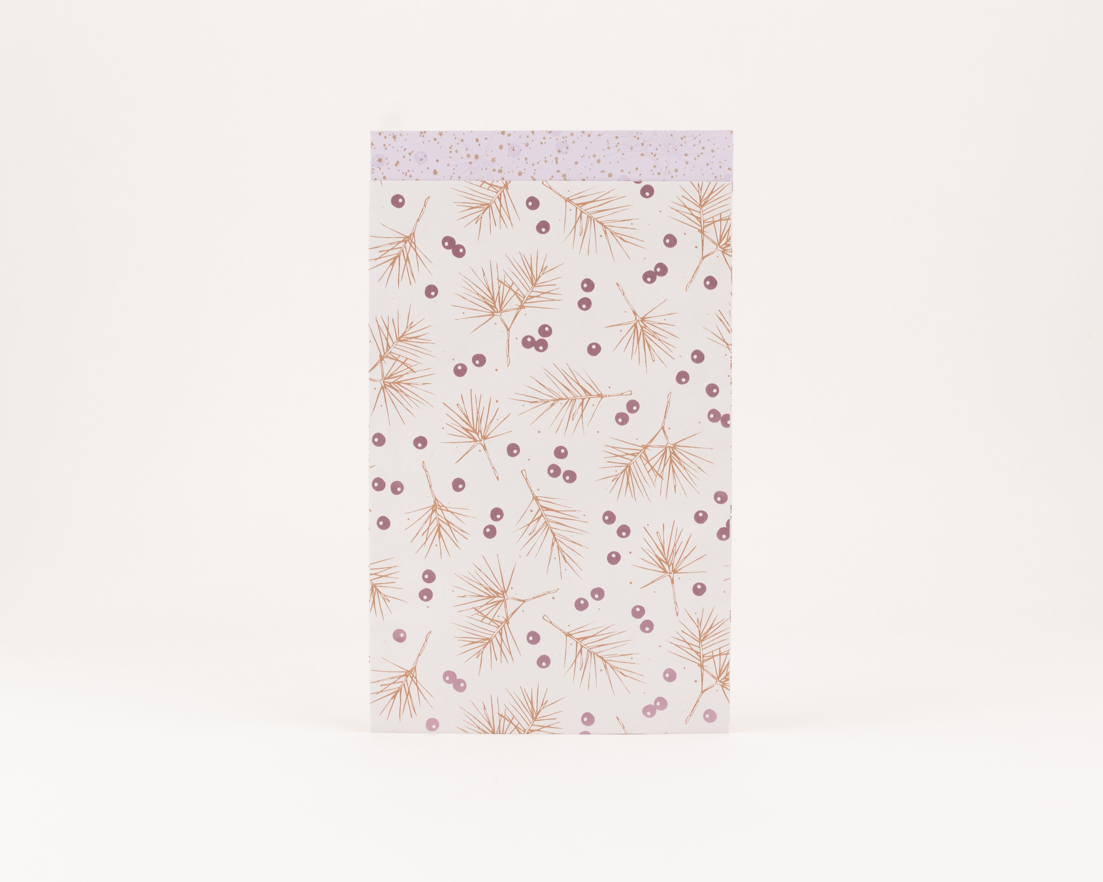 Flachbeutel auf cremeweißem Grund mit zimtfarbenen Tannen und rosa metallic Beeren sowie einer Innenseite in Rosa mit goldenen Punkten und Sternen.