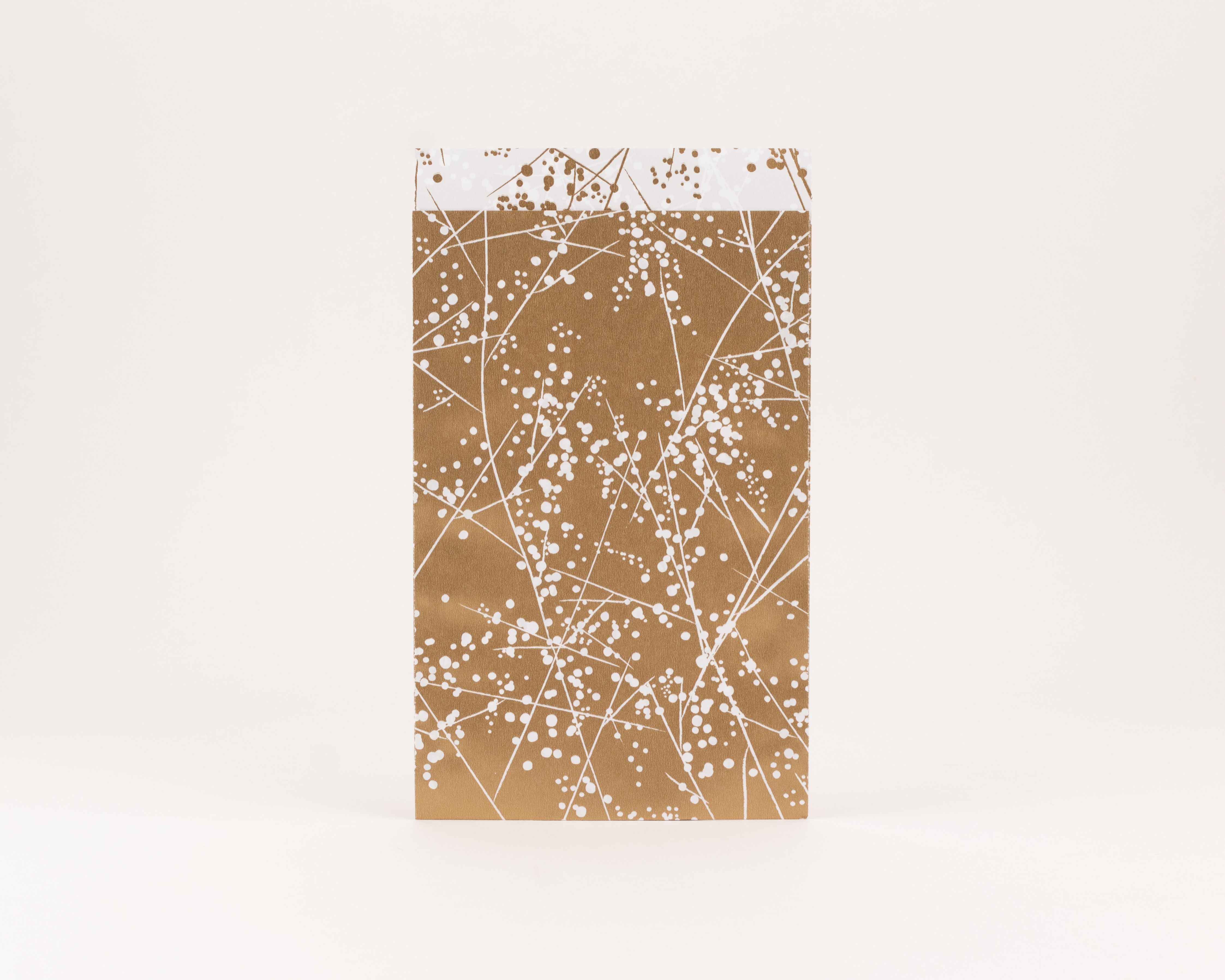 Flachbeutel mit goldener Außenseite und weißem Winterfrost-Muster. Die sichtbare Innenseite ist weiß mit goldenen Punkten verziert