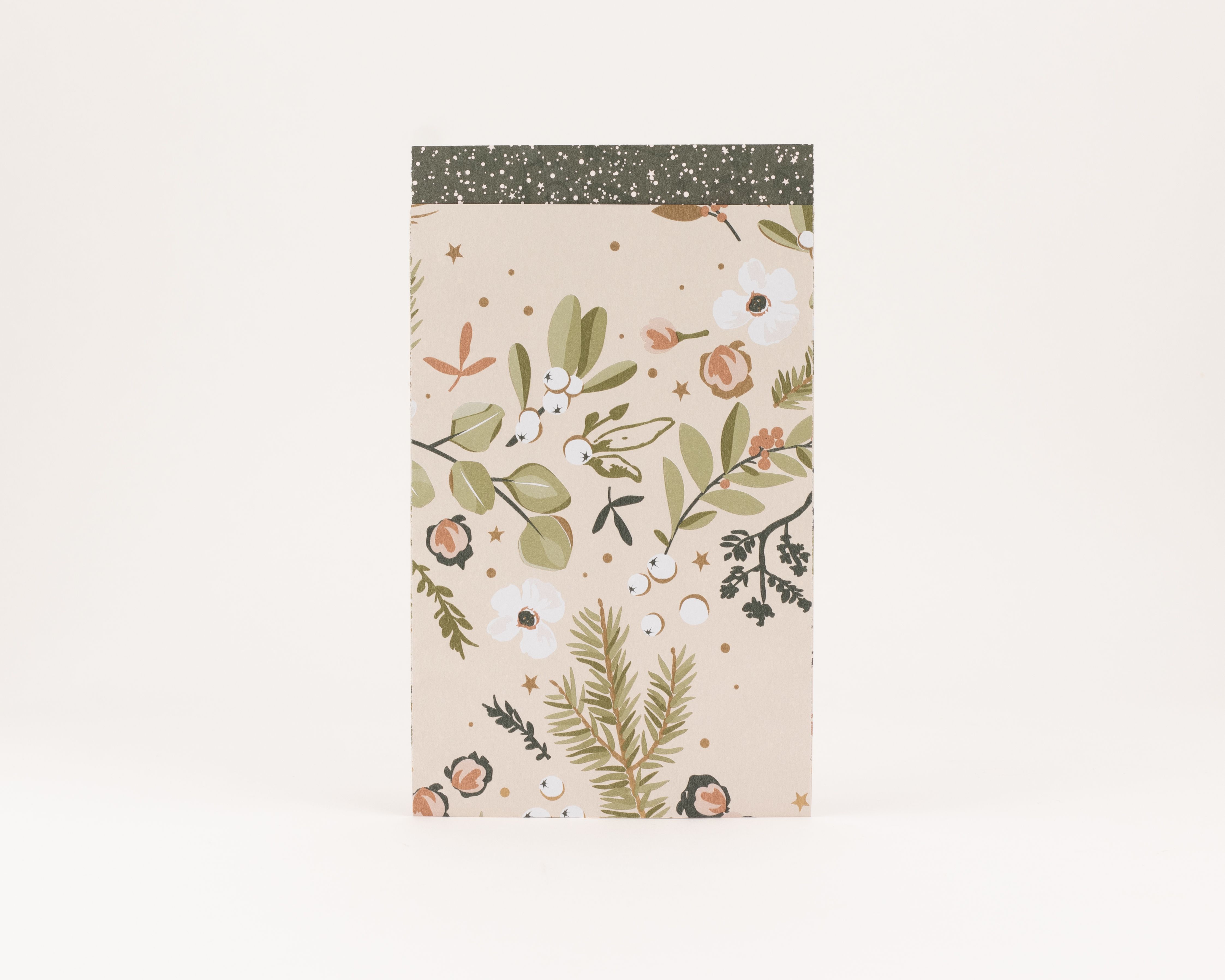 Flachbeutel mit beigem Hintergrund, winterlichem Blumendruck in Grün, Weiß, Pfirsich und Goldeffekt. Die Innenseite ist dunkelgrün mit weißen Sternen und Punkten
