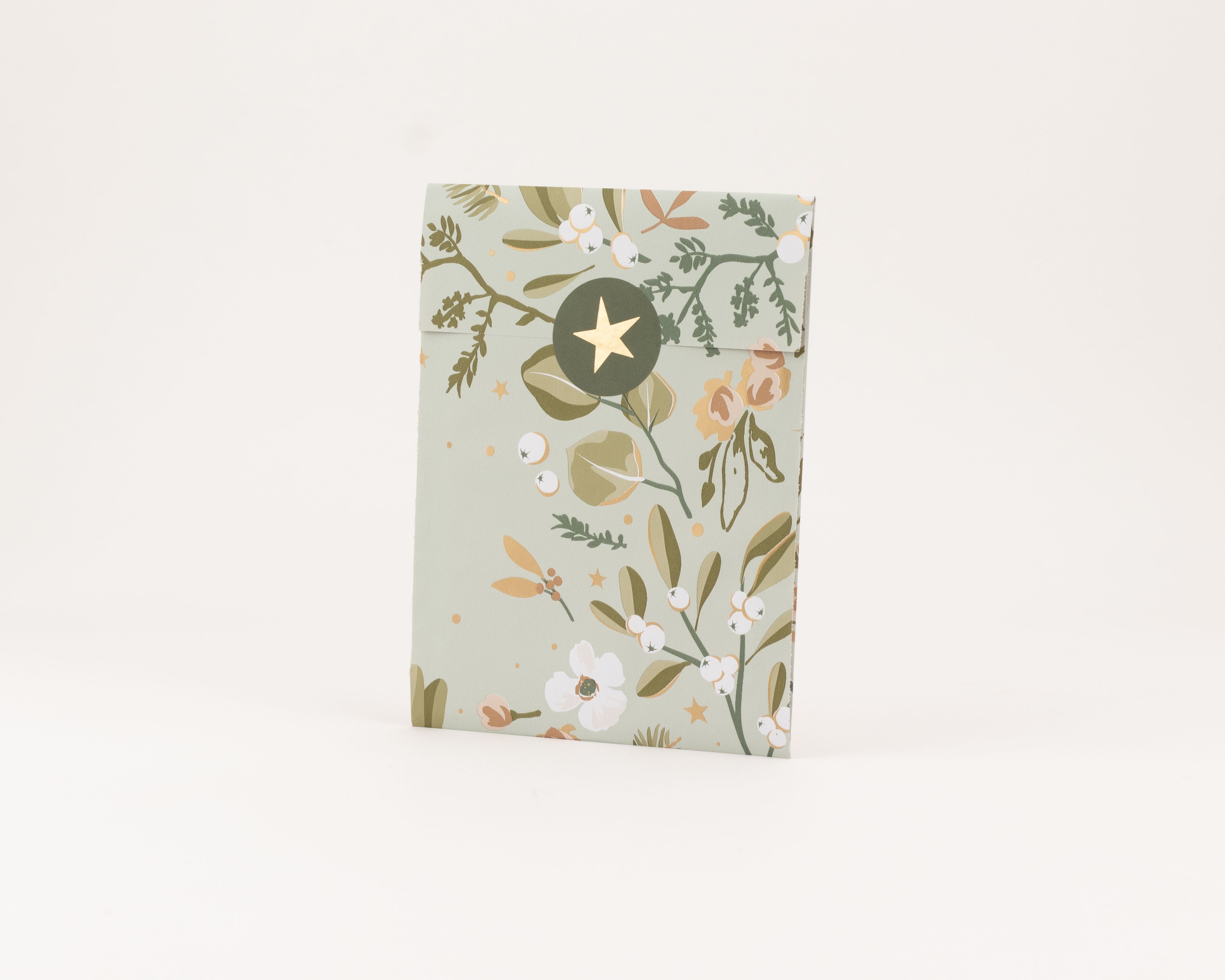 Flachbeutel in Salbeigrün mit botanischem Wintergarten-Muster und Goldeffekt-Details. Die Innenseite zeigt ein Sternenmotiv in Zimtbraun