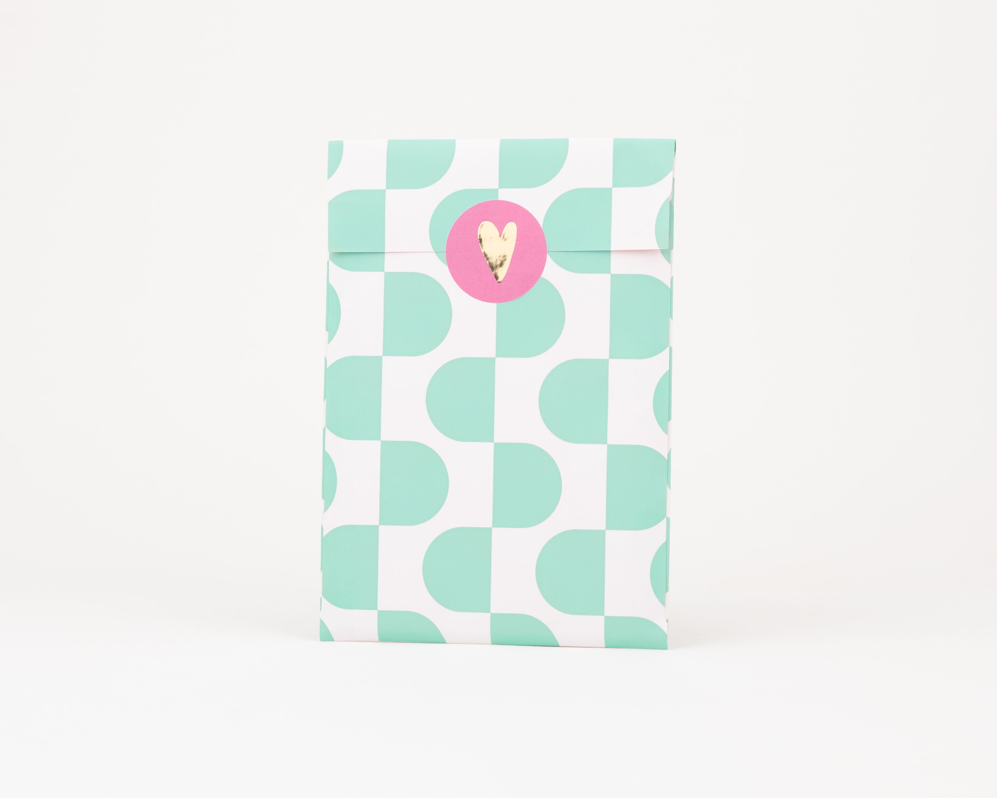 Papiertüten Flachbeutel zeigen ein Retro-Wellenmuster in Grün und Weiß. Die Innenseite ist mit einem Muster in Rosa und Orangerot gestaltet